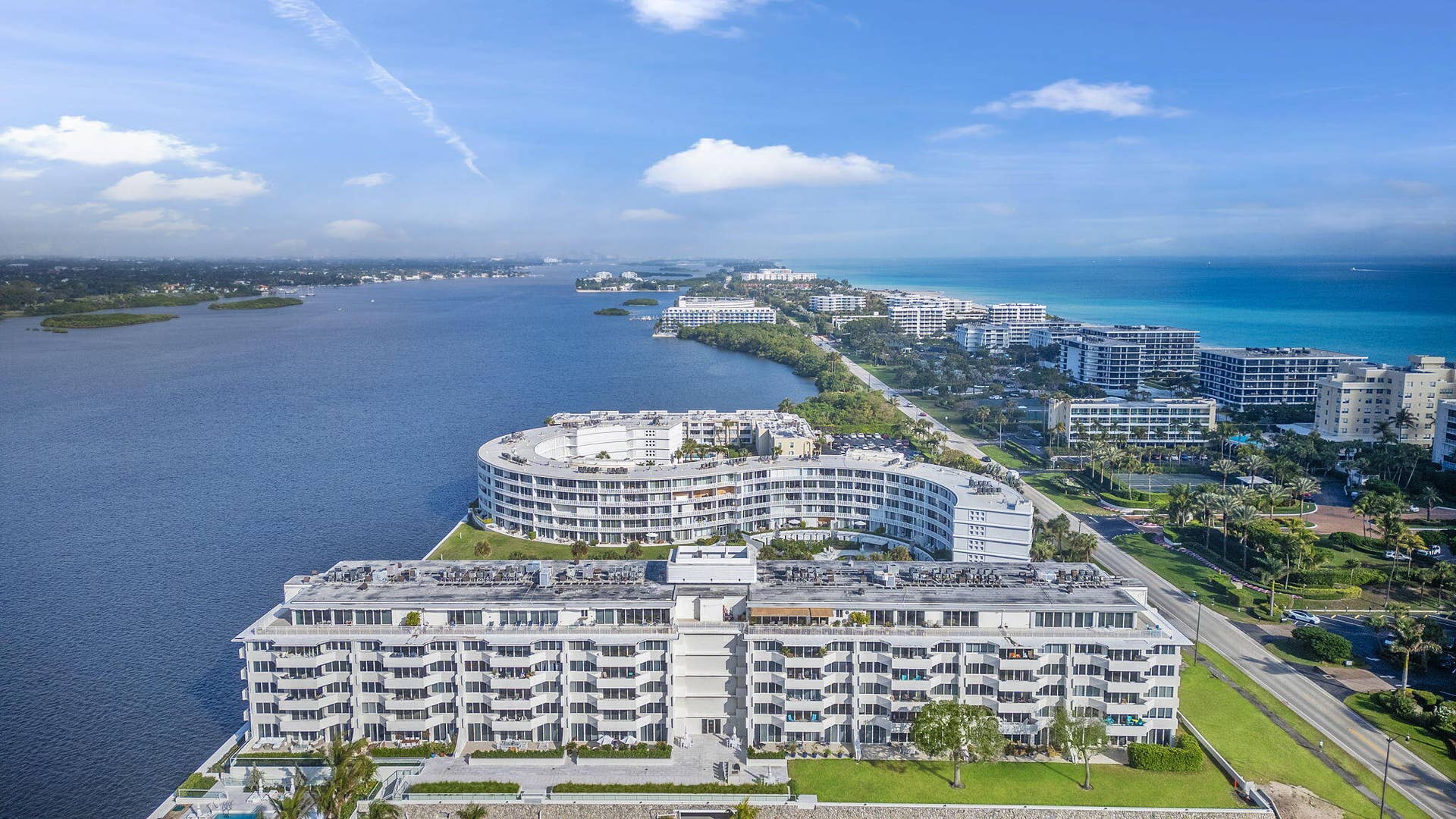 2773 S Ocean Boulevard, #517, Palm Beach, Palm Beach, FL 33480 Waterfront residential building with multiple balconies, positioned along a waterway with a prominent ocean backdrop