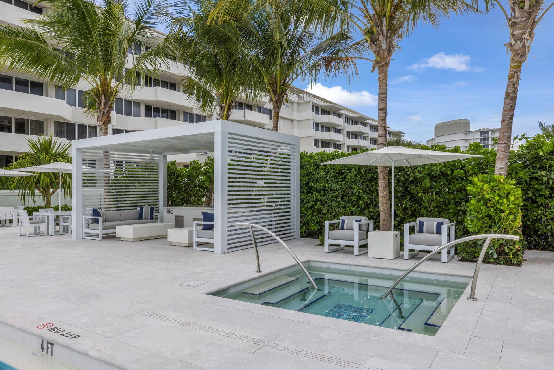 2773 S Ocean Boulevard, #517, Palm Beach, Palm Beach, FL 33480 Built-in spa with steps and grab rails, surrounding stone-finish paving, pergola structure, and extensive landscaping