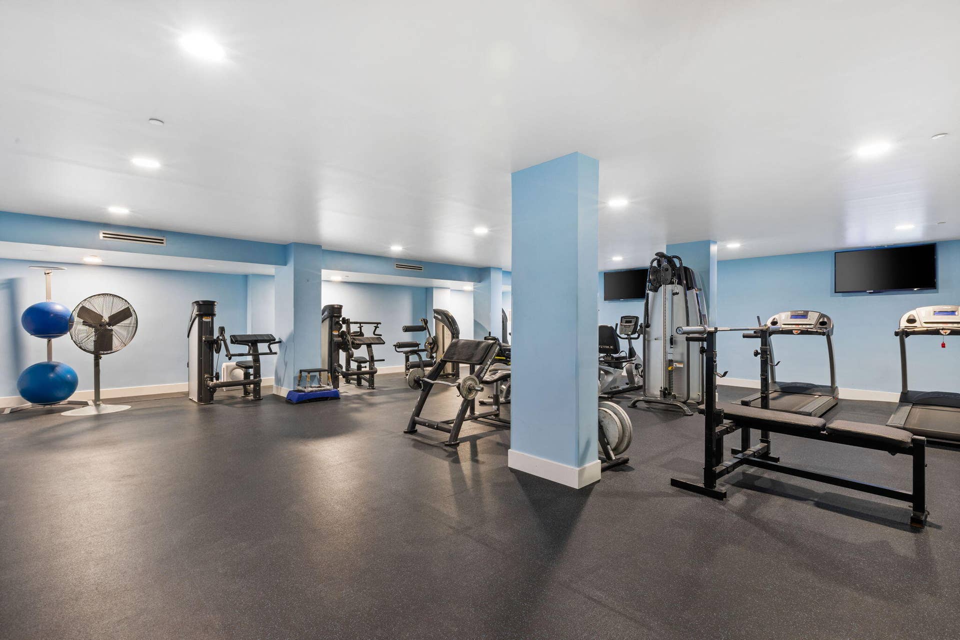 2773 S Ocean Boulevard, #517, Palm Beach, Palm Beach, FL 33480 Fitness center with recessed lighting, light blue accent walls, and mounted television screens