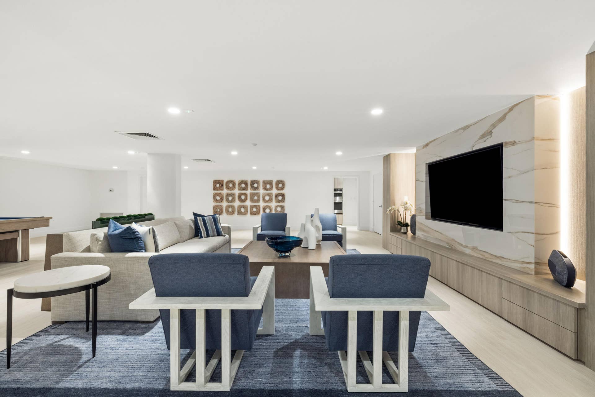 2773 S Ocean Boulevard, #517, Palm Beach, Palm Beach, FL 33480 Recessed ceiling lighting, light wood-finish flooring, built-in entertainment unit with integrated lighting, a stone-finish accent wall, and a column-free open-concept layout