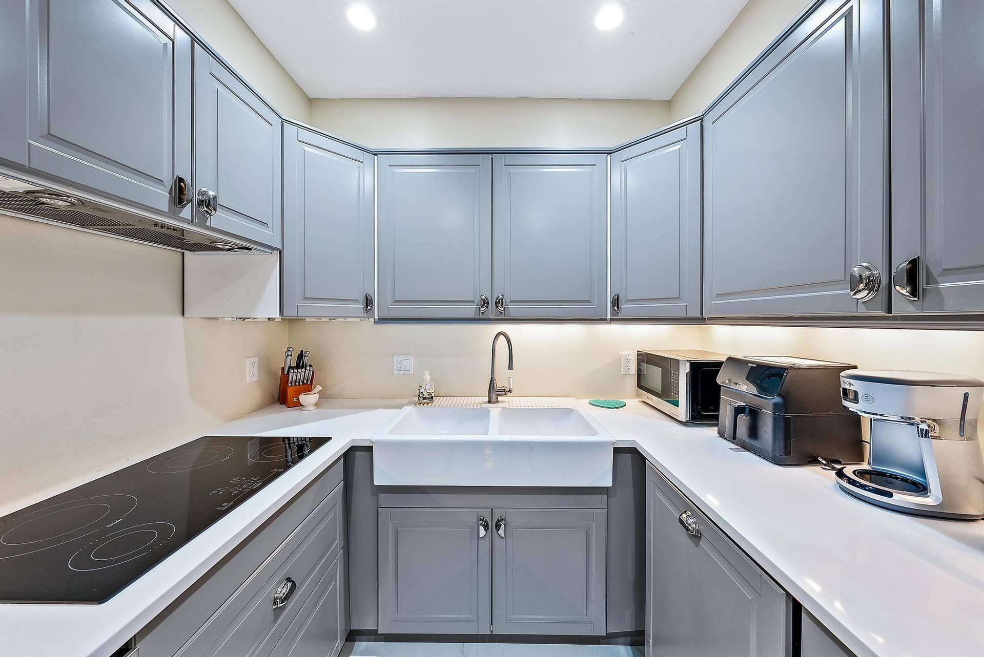 2773 S Ocean Boulevard, #517, Palm Beach, Palm Beach, FL 33480 U-shaped kitchen featuring grey shaker cabinetry, white countertops, a flat-top electric range, and an apron-front sink with a gooseneck faucet