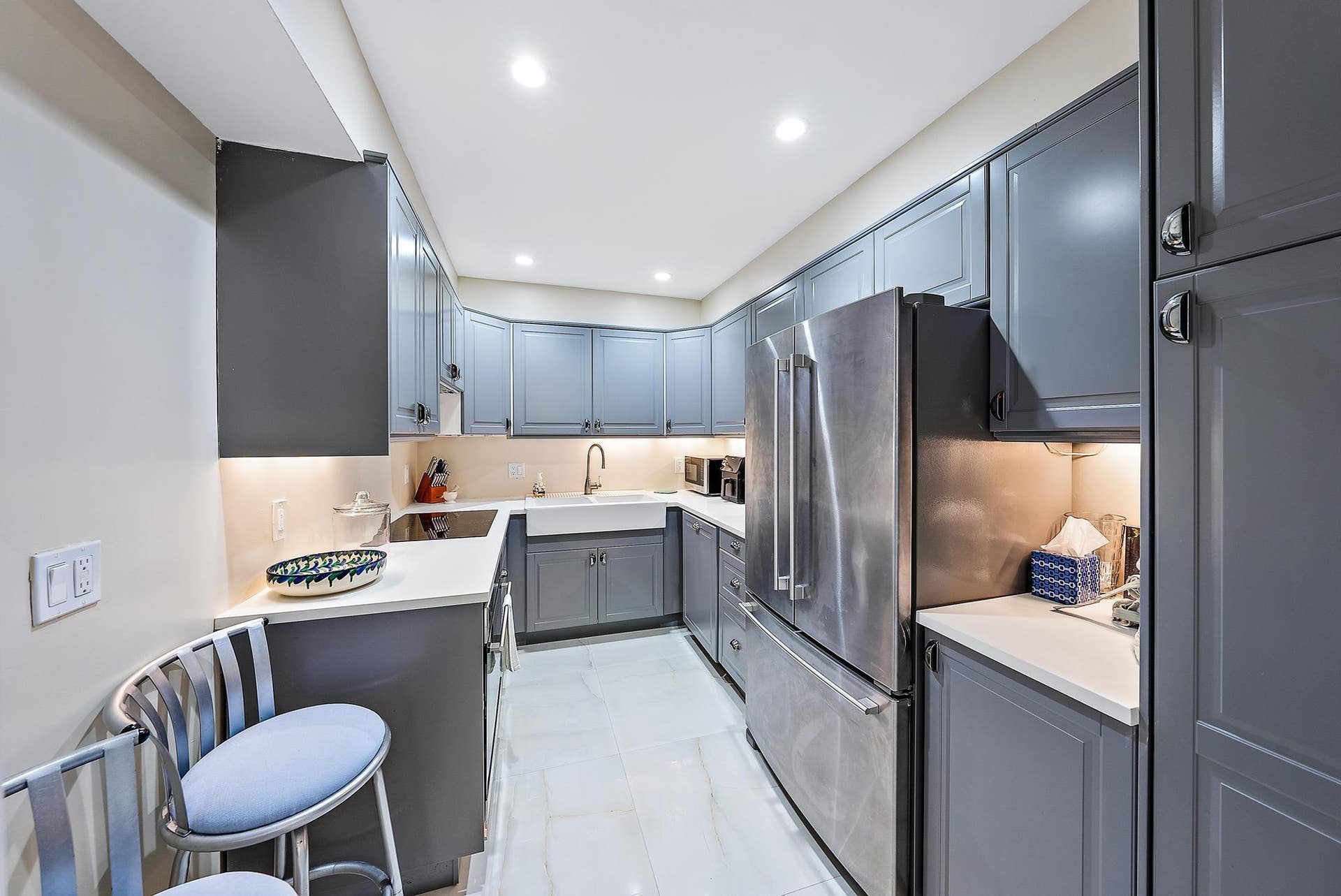 2773 S Ocean Boulevard, #517, Palm Beach, Palm Beach, FL 33480 Galley kitchen featuring gray cabinetry, stainless steel appliances, a white farmhouse sink, and under-cabinet lighting