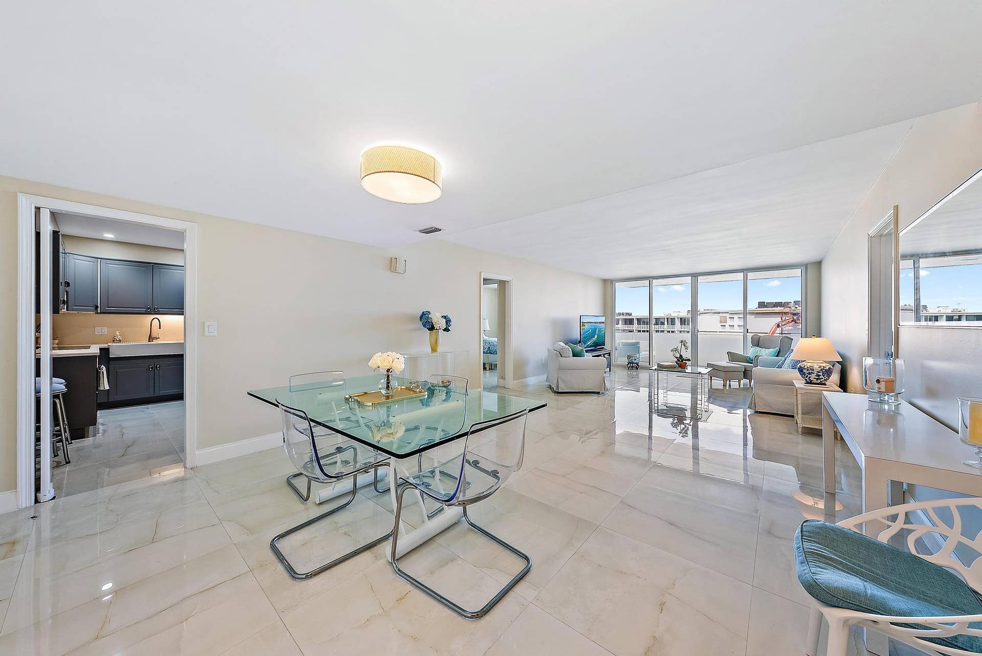 2773 S Ocean Boulevard, #517, Palm Beach, Palm Beach, FL 33480 Expansive open-concept living area showcasing polished light-stone flooring, floor-to-ceiling windows with panoramic outlooks, recessed ceiling lighting, and a modern glass-top dining table with sculptural base