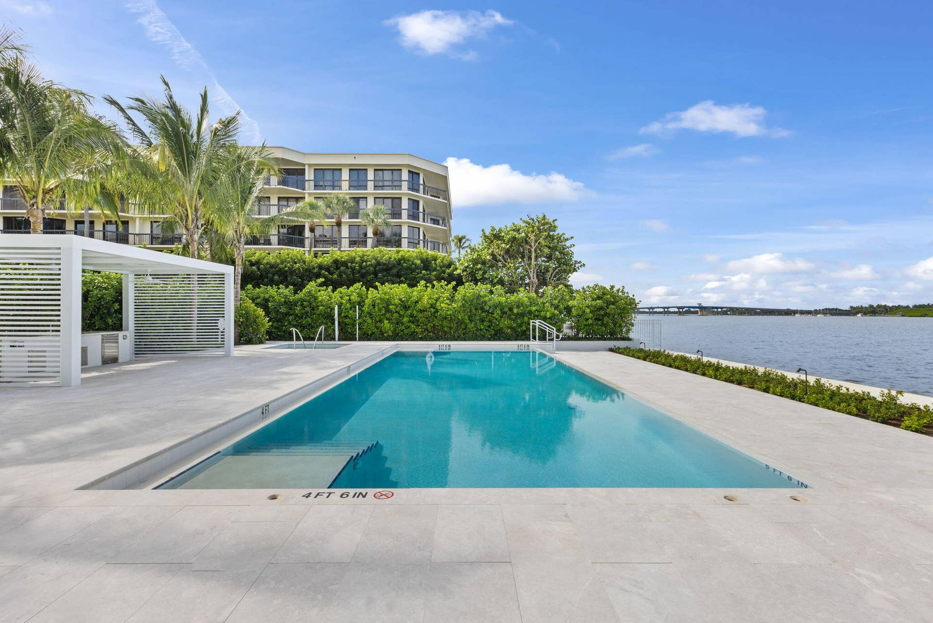 2773 S Ocean Boulevard, #517, Palm Beach, Palm Beach, FL 33480 In-ground swimming pool, white pergola, hardscaping with light-toned pavers, mature landscaping, and waterfront access