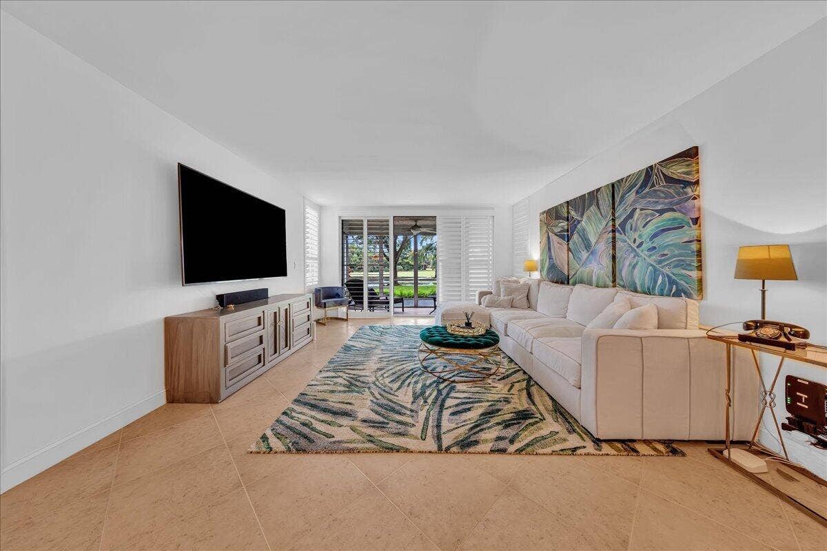 3505 Oaks Way, #109, Pompano Beach, FL 33069 Expansive living area with neutral tile flooring and direct access to the patio