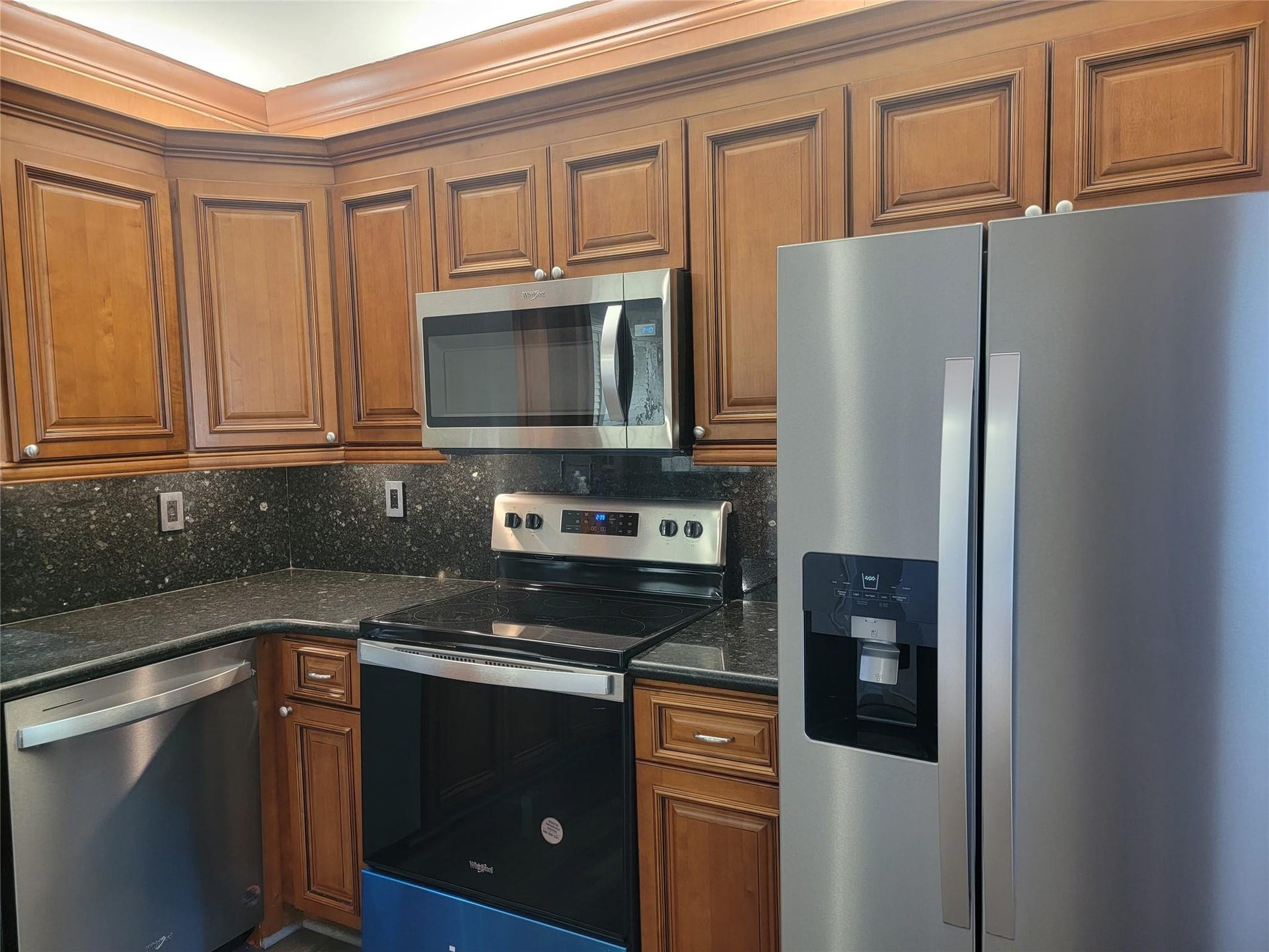 1001 SE 6TH Avenue, #127, Deerfield Beach, Deerfield Beach, FL 33441 Kitchen featuring stainless steel appliances, dark stone countertops, wood cabinetry, and a built-in microwave