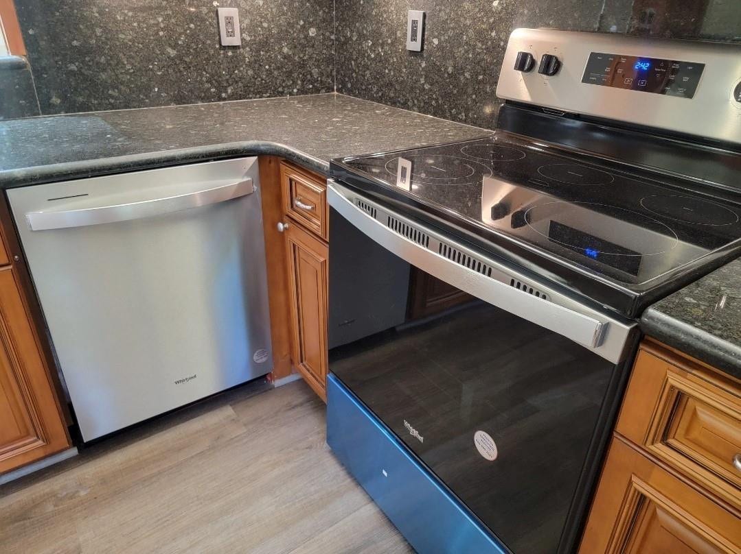 1001 SE 6TH Avenue, #127, Deerfield Beach, Deerfield Beach, FL 33441 Stainless steel dishwasher, coordinating stainless steel range with ceramic cooktop, stone-finish countertops, wood cabinetry, and wood-finish flooring