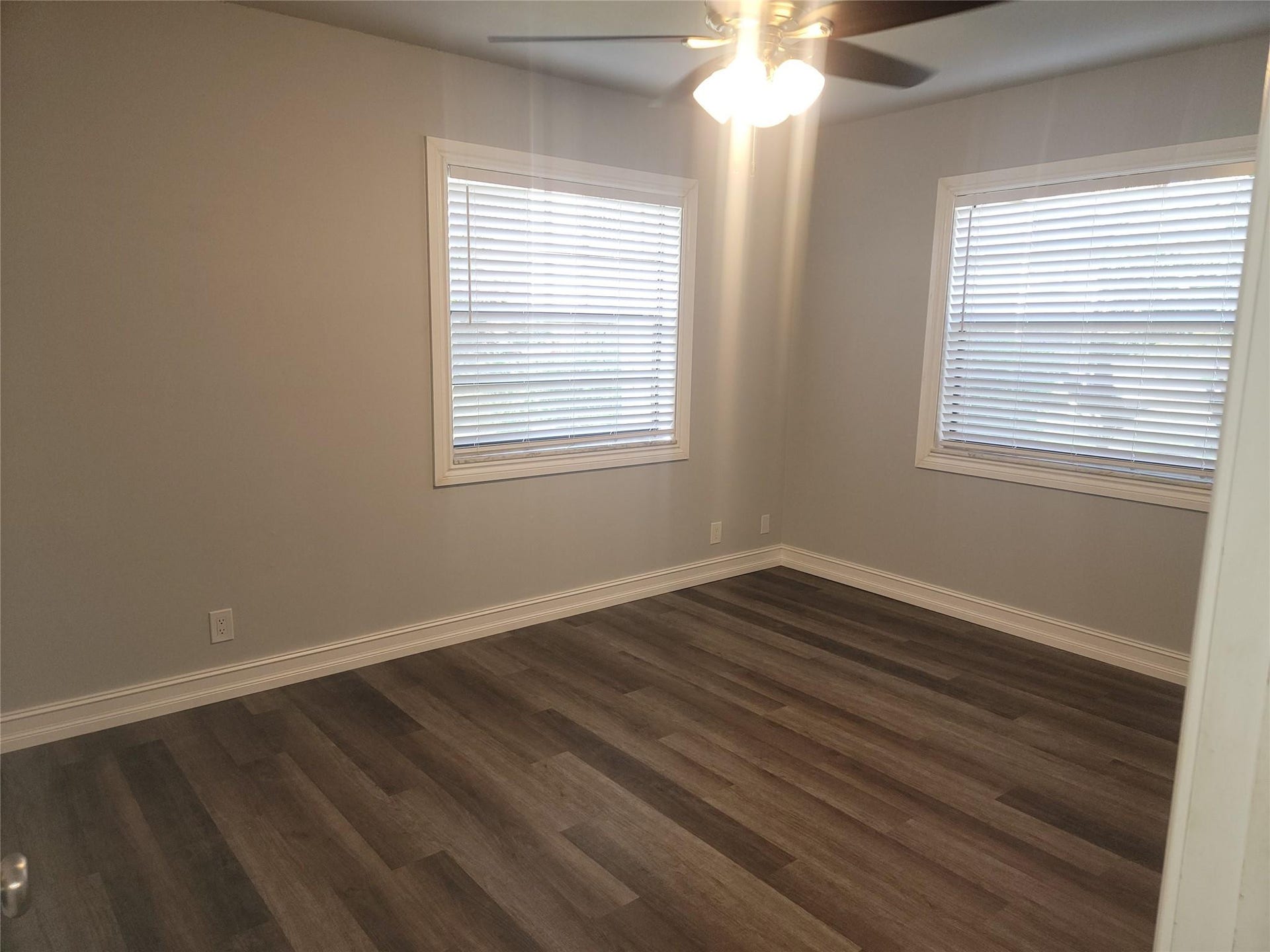 1001 SE 6TH Avenue, #127, Deerfield Beach, Deerfield Beach, FL 33441 Wood-finish flooring, neutral wall tones, two windows with blinds, and a ceiling fan with integrated lighting