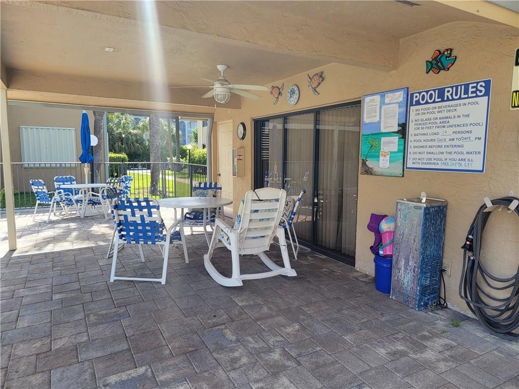 1001 SE 6TH Avenue, #127, Deerfield Beach, Deerfield Beach, FL 33441 Covered patio area featuring a ceiling fan, sliding glass door, and paver flooring
