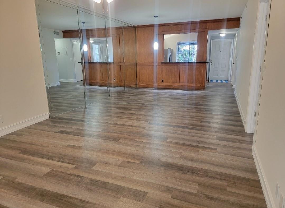 1001 SE 6TH Avenue, #127, Deerfield Beach, Deerfield Beach, FL 33441 Wood-finish flooring throughout, mirrored accent wall, and built-in wood cabinetry with a serving bar