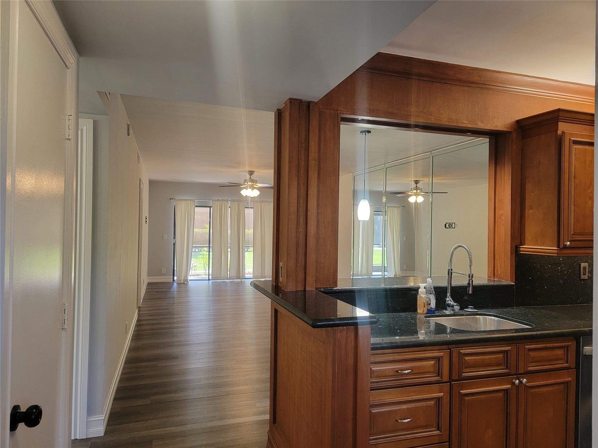 1001 SE 6TH Avenue, #127, Deerfield Beach, Deerfield Beach, FL 33441 Kitchen pass-through with wood cabinetry, dark countertops, and a stainless steel sink