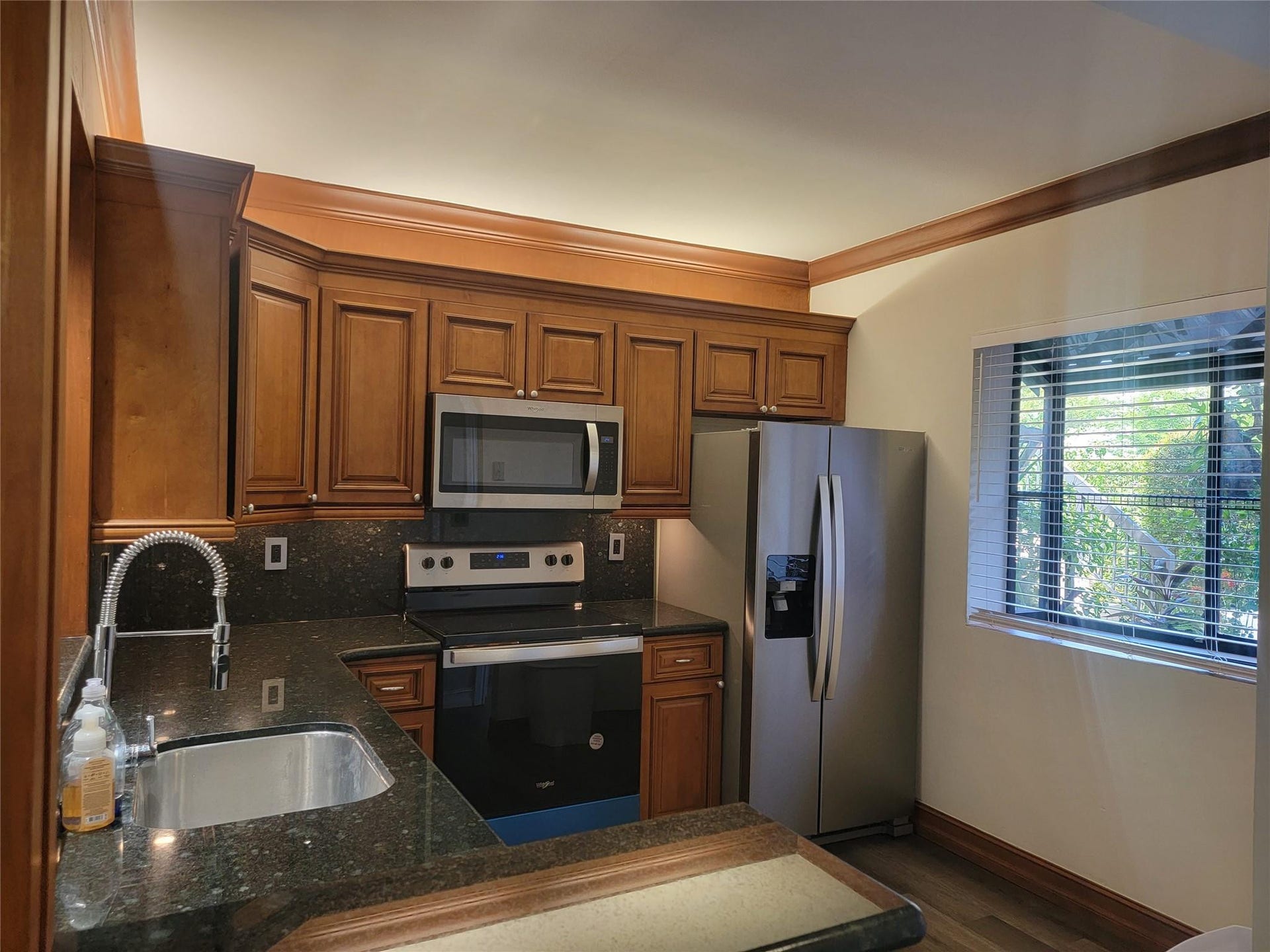 1001 SE 6TH Avenue, #127, Deerfield Beach, Deerfield Beach, FL 33441 Kitchen featuring wood-finish cabinetry, dark speckled countertops, and stainless steel appliances