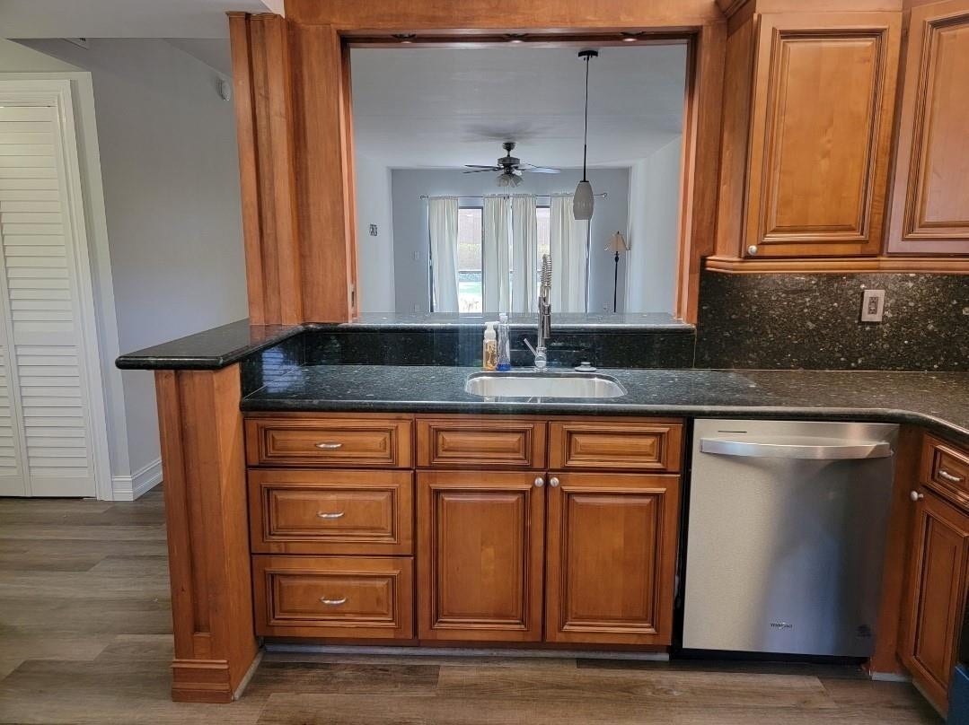 1001 SE 6TH Avenue, #127, Deerfield Beach, Deerfield Beach, FL 33441 Kitchen featuring wood-finish cabinetry, dark speckled countertops, a stainless steel sink, and a stainless steel dishwasher