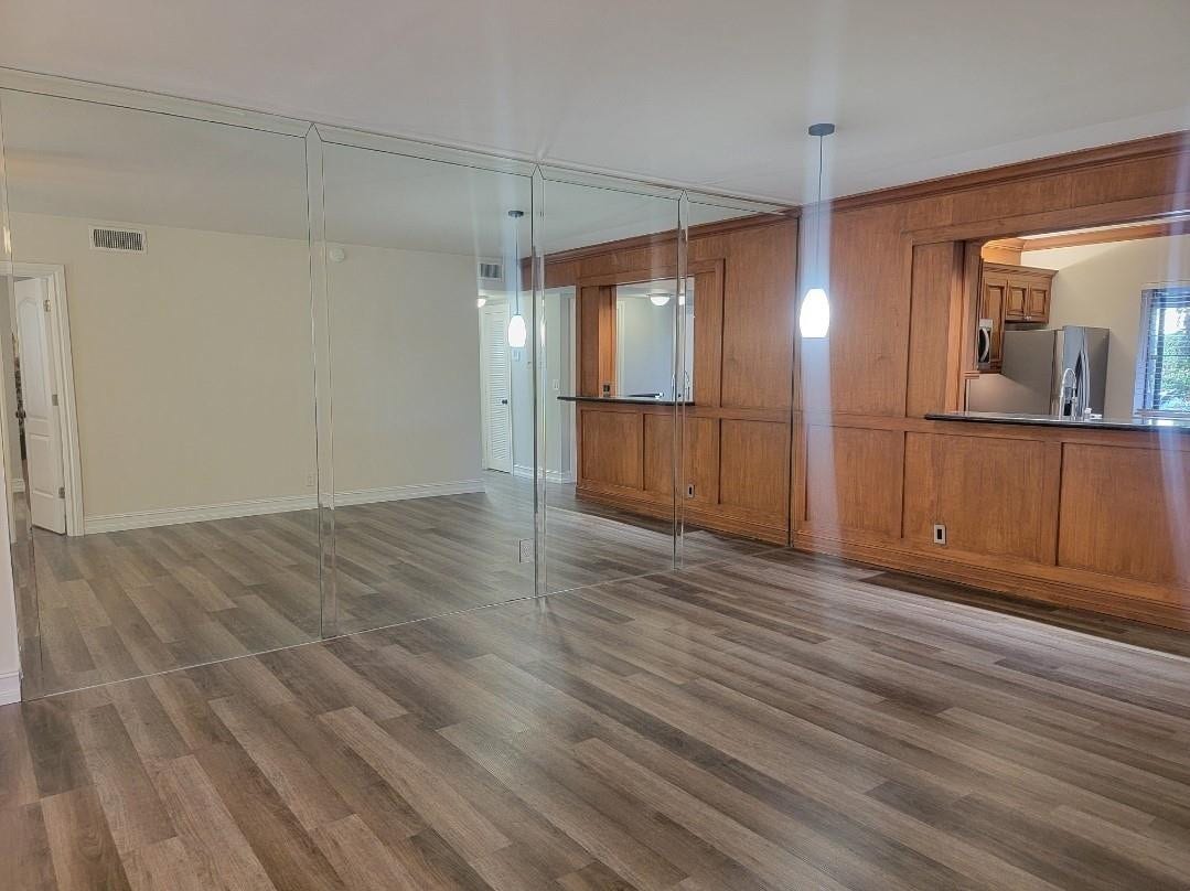 1001 SE 6TH Avenue, #127, Deerfield Beach, Deerfield Beach, FL 33441 Wood-finish flooring, full-height mirror wall, wood paneling, built-in cabinetry, and pendant lighting