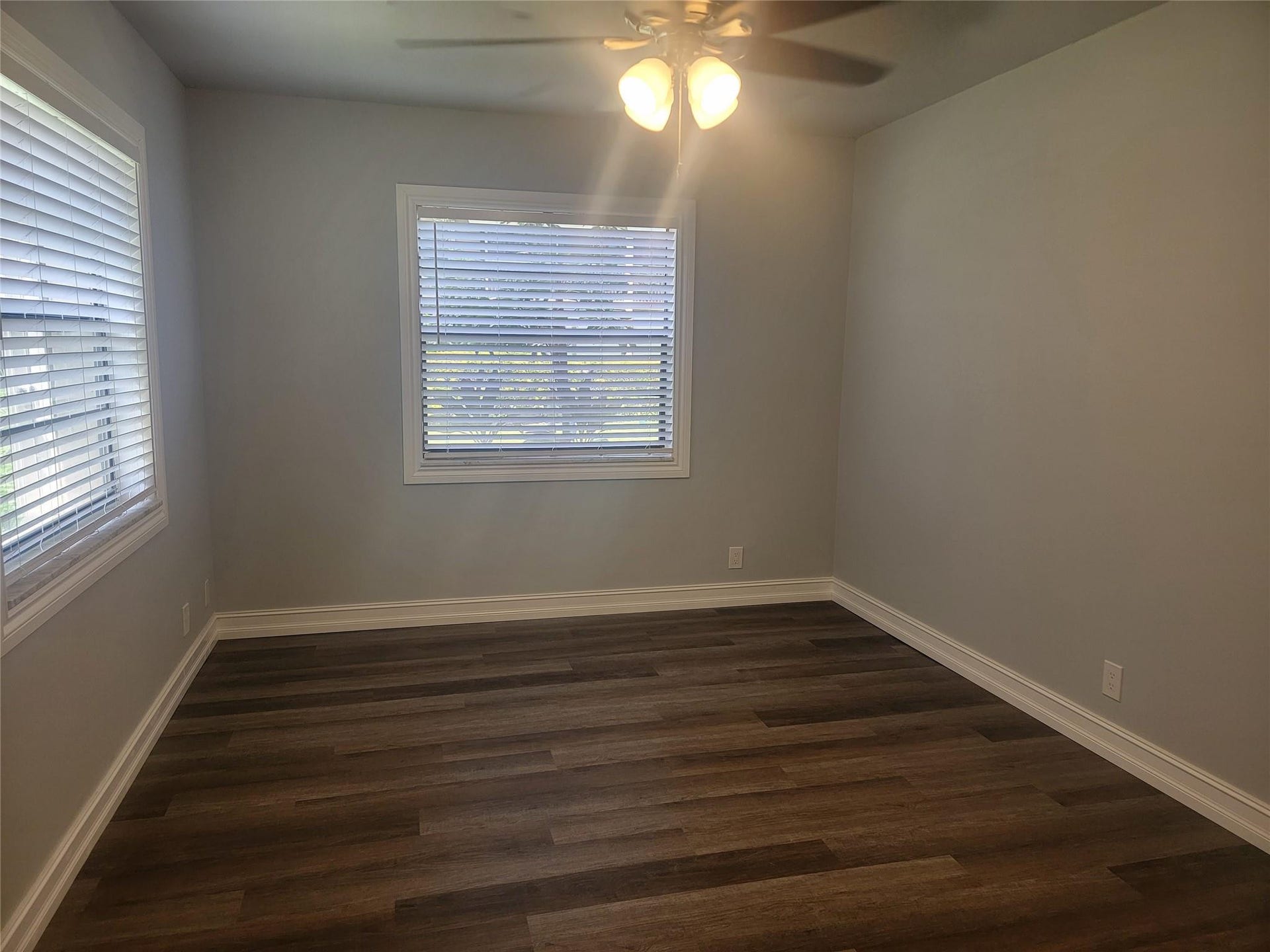 1001 SE 6TH Avenue, #127, Deerfield Beach, Deerfield Beach, FL 33441 Wood-finish flooring, two windows with blinds, ceiling fan with integrated lighting, and neutral wall tones