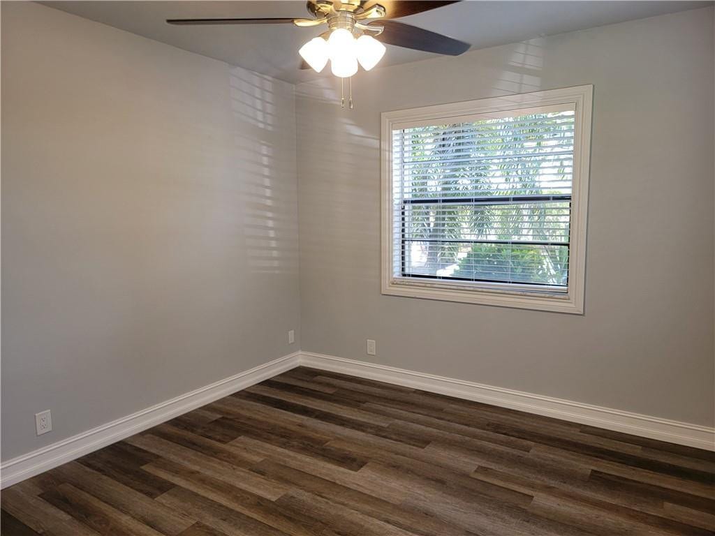1001 SE 6TH Avenue, #127, Deerfield Beach, Deerfield Beach, FL 33441 Wood-finish flooring, white trim, light gray walls, window with blinds, and a ceiling fan with integrated lighting