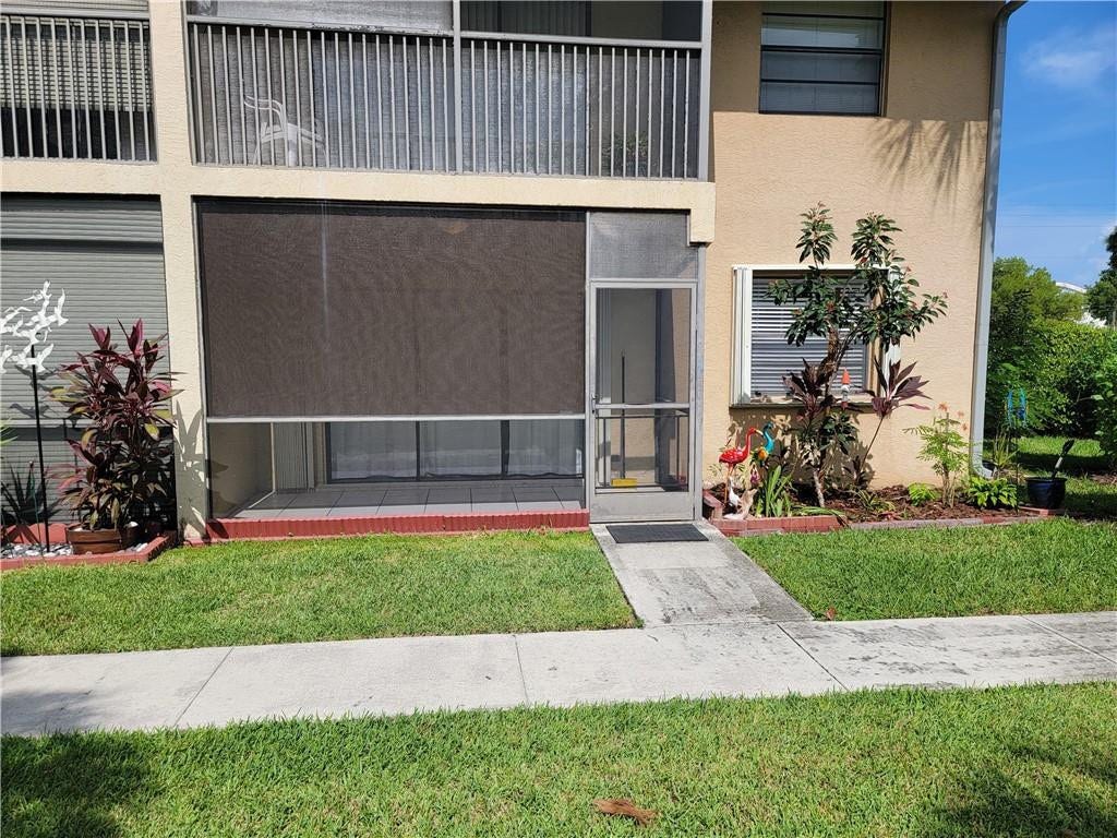 1001 SE 6TH Avenue, #127, Deerfield Beach, Deerfield Beach, FL 33441 Screened patio with privacy shade, concrete walkway, and landscaped garden beds