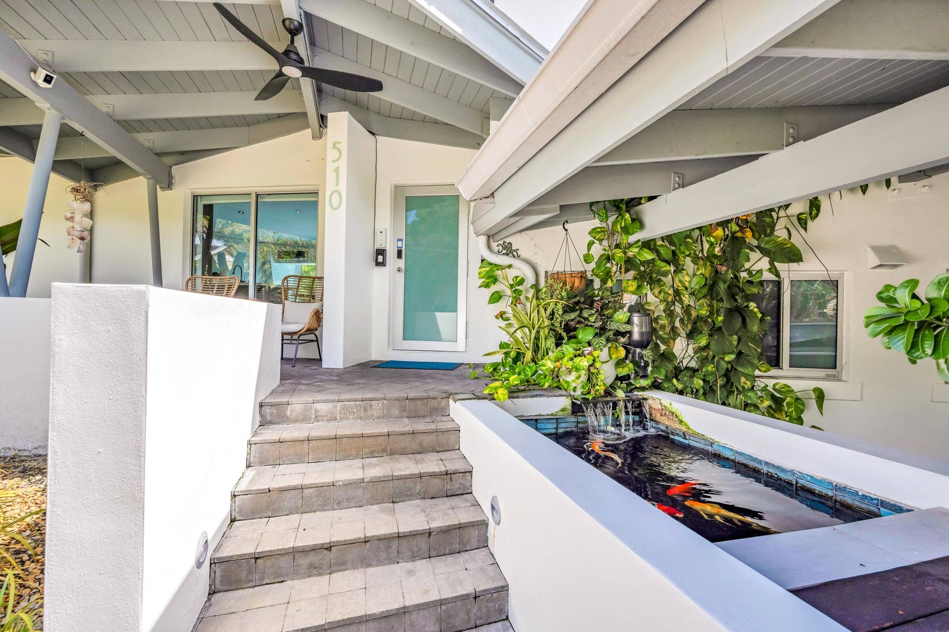 510 SW 18th Avenue, Fort Lauderdale, FL 33312 Covered entry with exposed beam ceiling, built-in koi pond with waterfall feature, and paver steps