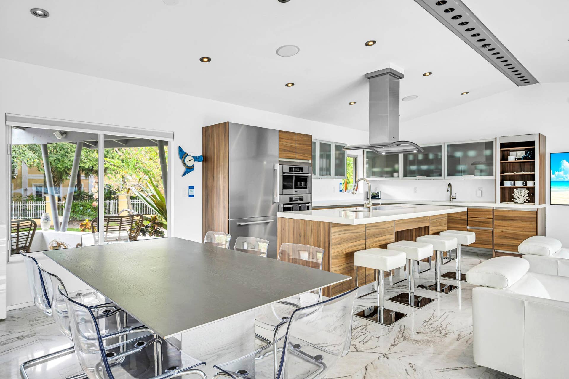 510 SW 18th Avenue, Fort Lauderdale, FL 33312 Open-concept kitchen with wood-finish cabinetry, stainless steel appliances, and a central island with a sink