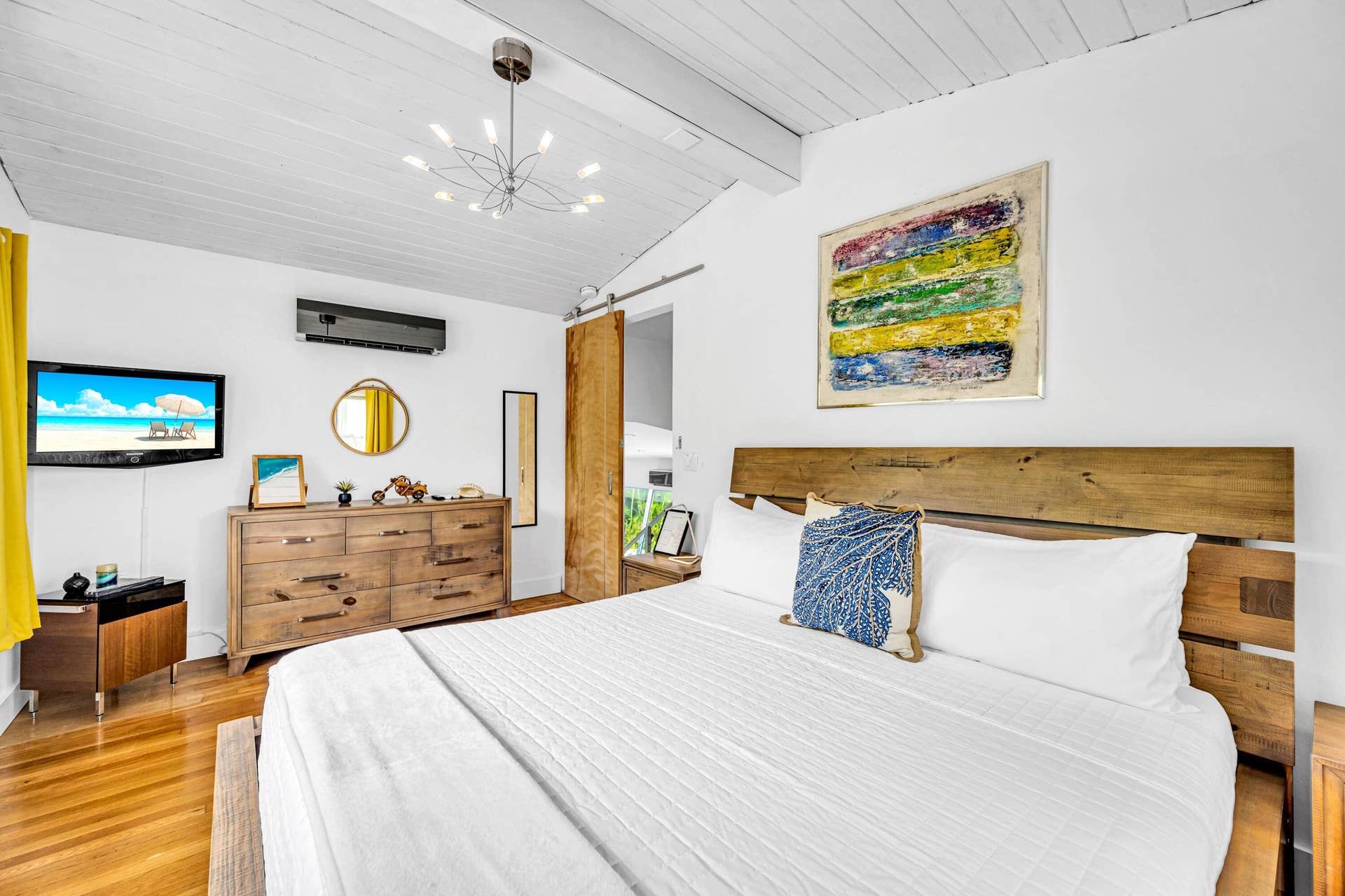 510 SW 18th Avenue, Fort Lauderdale, FL 33312 Vaulted wood-paneled ceiling, wood-finish flooring, ceiling-mounted light fixture, wall-mounted air conditioning unit, and a barn door