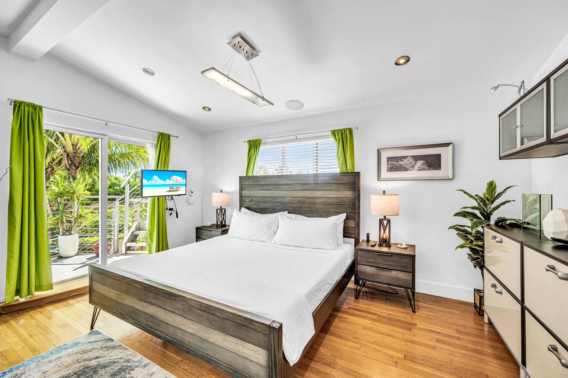 510 SW 18th Avenue, Fort Lauderdale, FL 33312 Sliding glass door leading to an outdoor balcony, wood-finish flooring, recessed lighting, and a modern linear pendant light fixture