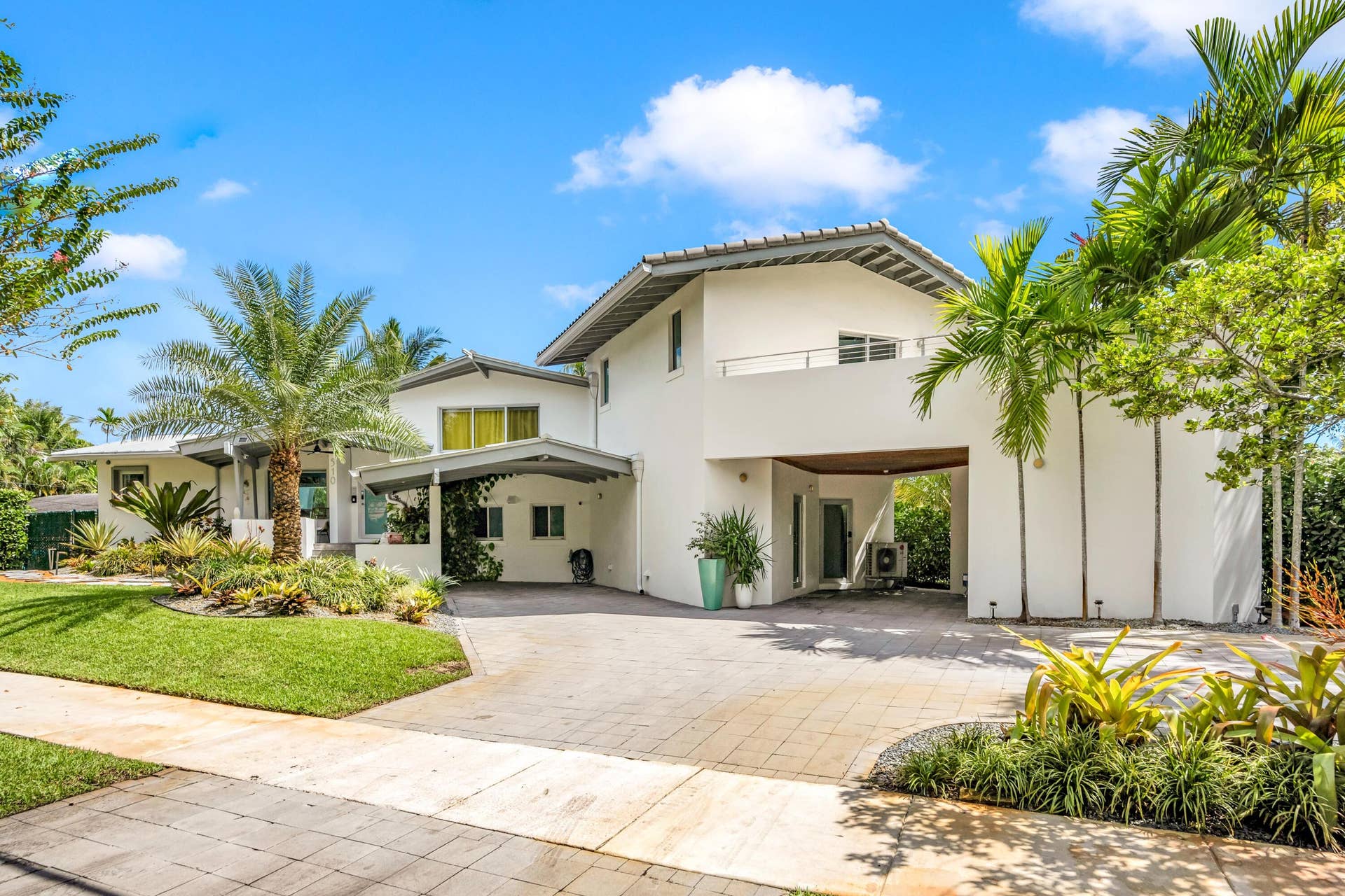 510 SW 18th Avenue, Fort Lauderdale, FL 33312 Contemporary white stucco exterior with multiple rooflines, lush tropical landscaping, and an expansive paver driveway