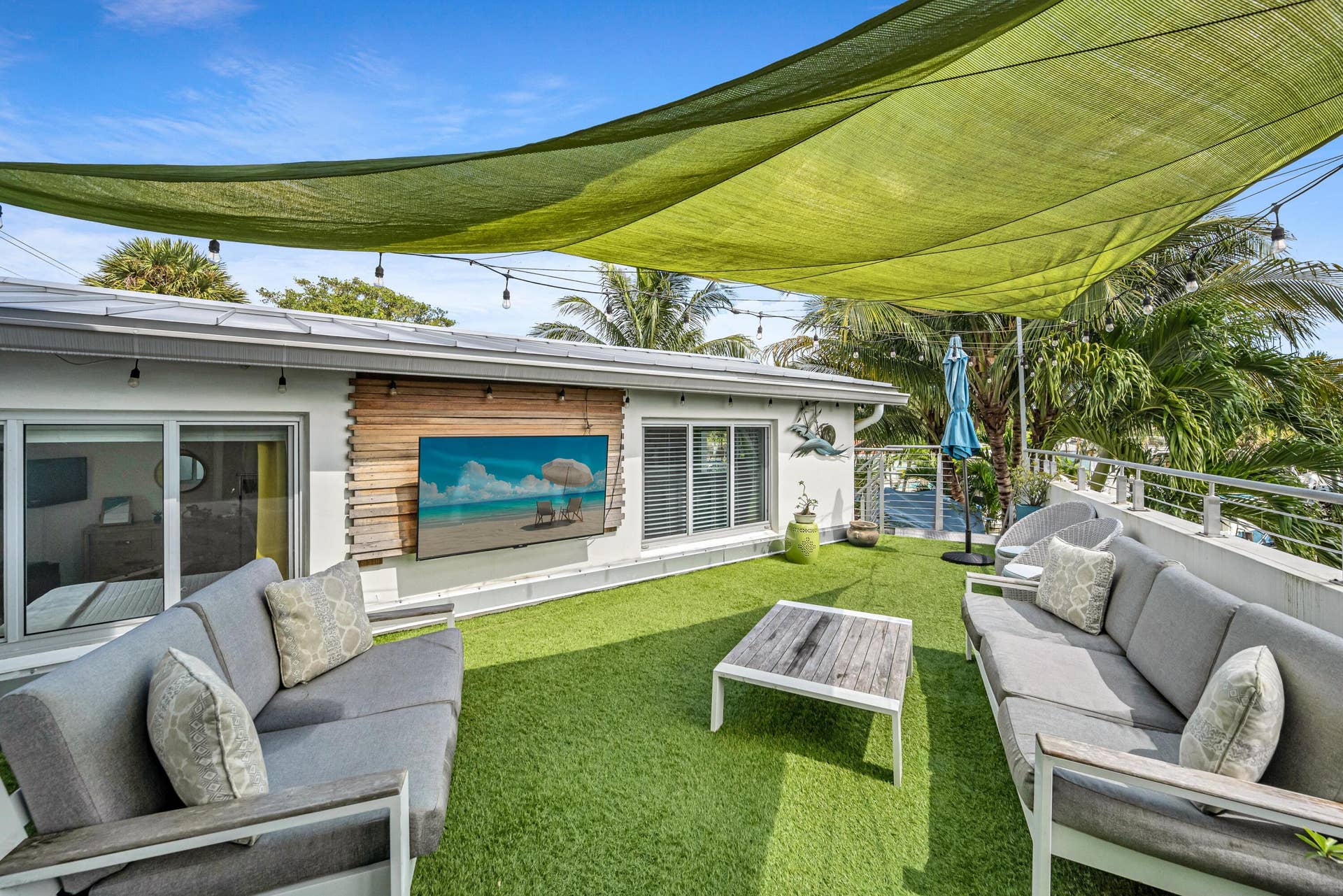 510 SW 18th Avenue, Fort Lauderdale, FL 33312 Rooftop patio featuring an artificial turf surface, a large shade canopy, an outdoor media display, and a modern railing