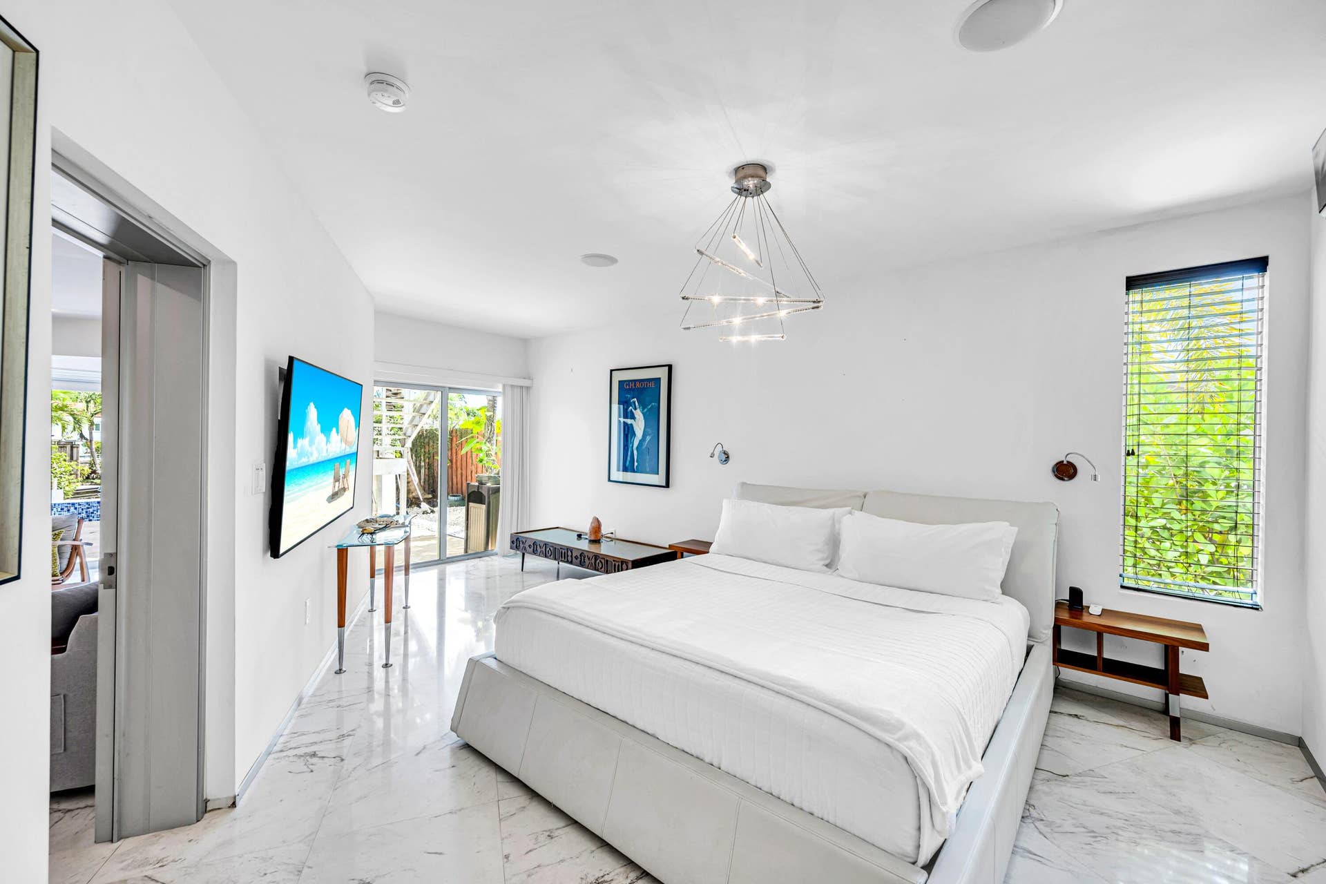 510 SW 18th Avenue, Fort Lauderdale, FL 33312 Bright interior with white walls, sliding glass doors, white marble-look tile flooring, and a modern geometric light fixture