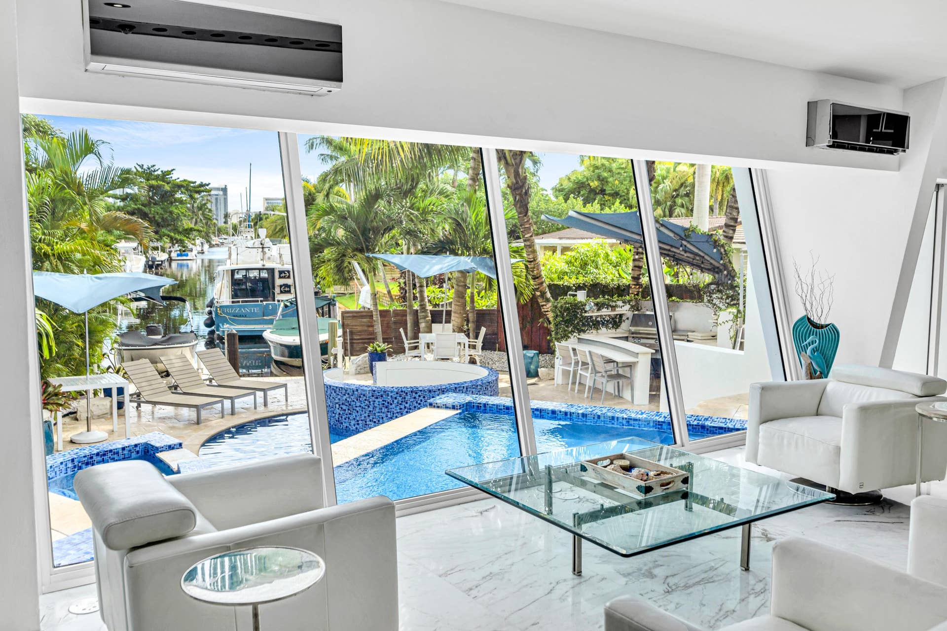 510 SW 18th Avenue, Fort Lauderdale, FL 33312 Expansive windows overlooking a pool with blue mosaic tile and a waterway