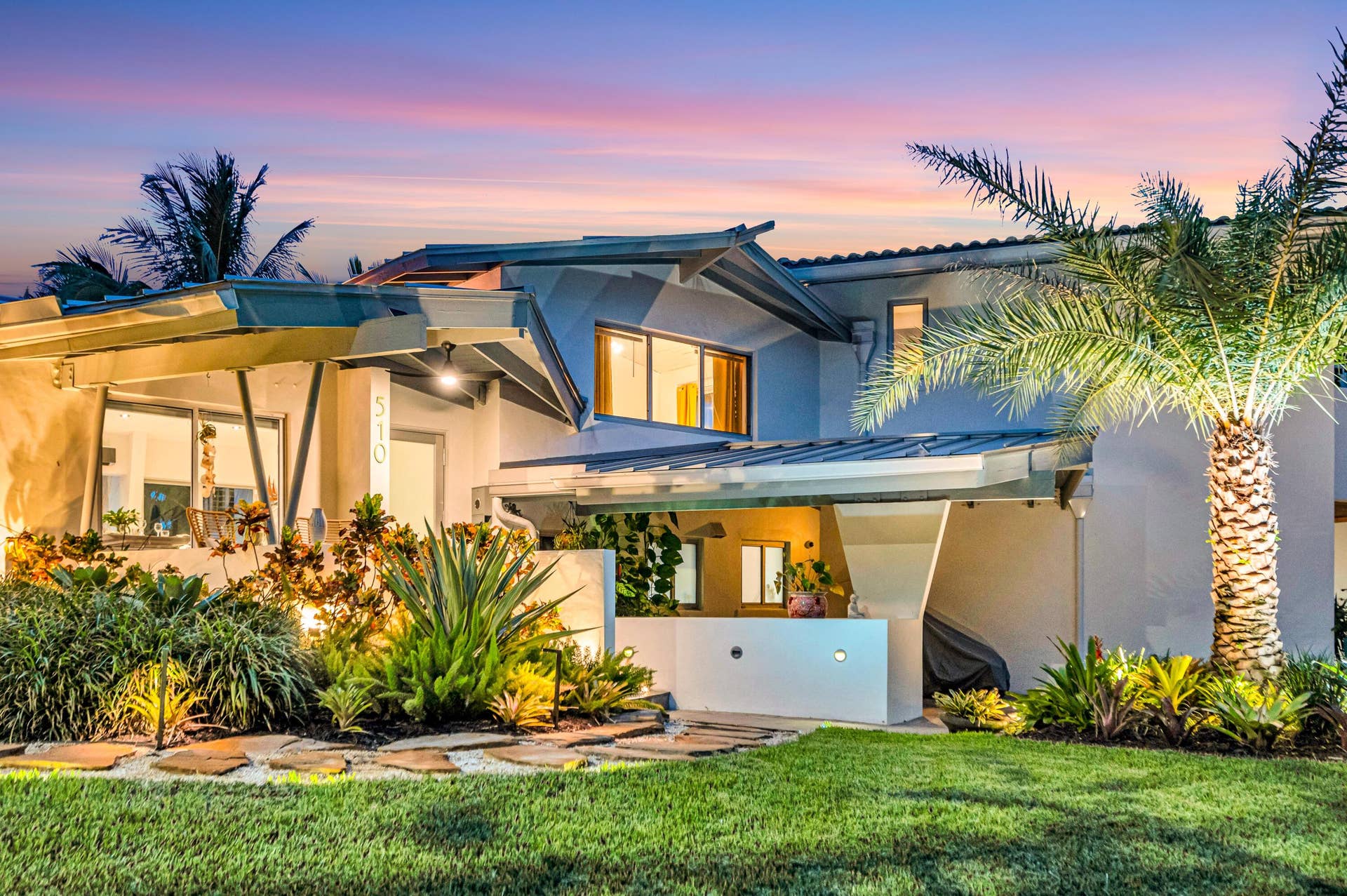 510 SW 18th Avenue, Fort Lauderdale, FL 33312 Modern exterior architecture with multiple rooflines, lush landscaping, exterior lighting, an expansive lawn, and a prominent palm tree