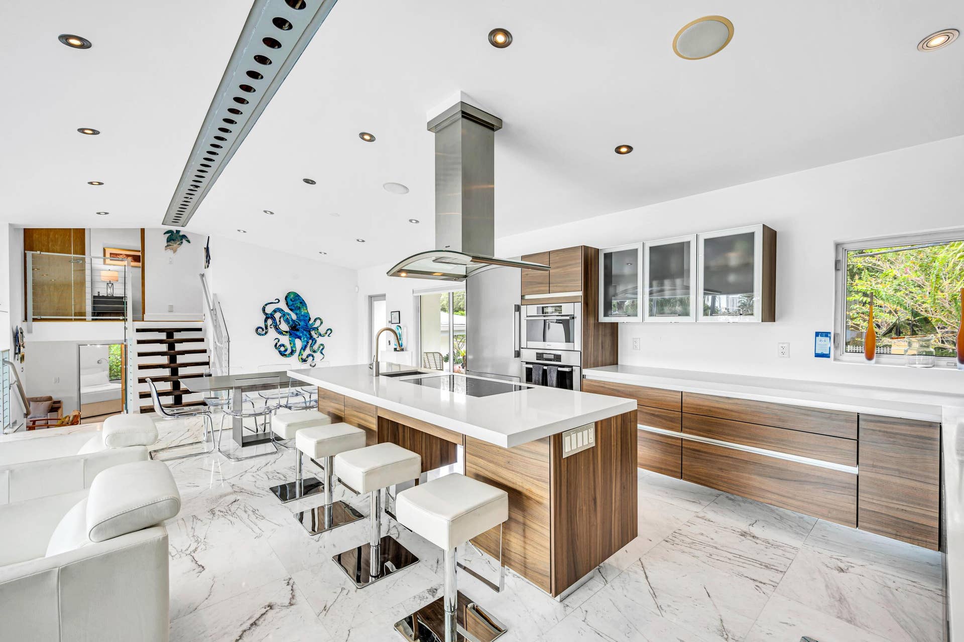 510 SW 18th Avenue, Fort Lauderdale, FL 33312 Open-concept kitchen featuring an expansive island, wood-finish cabinetry, integrated stainless steel appliances, and recessed lighting