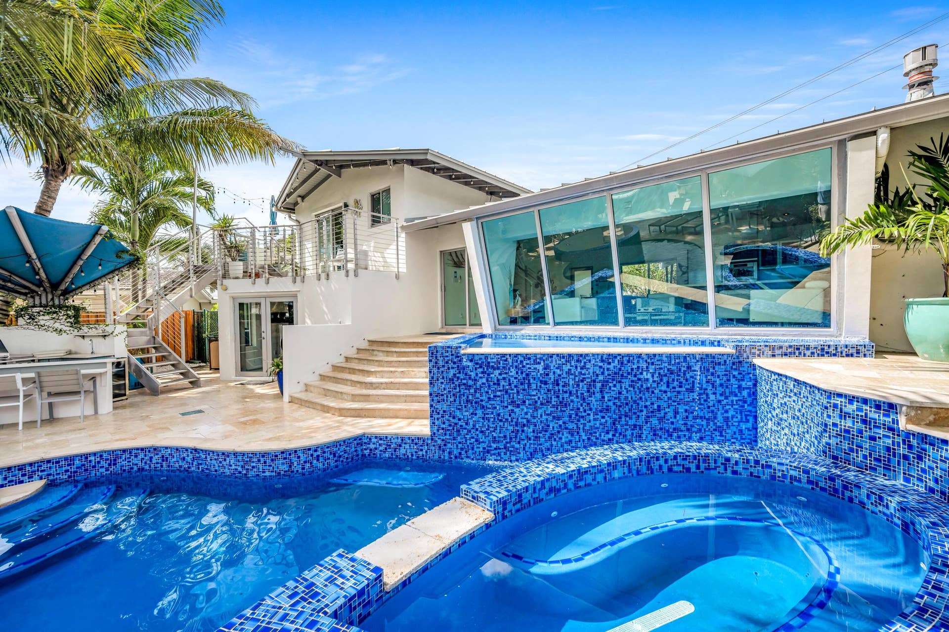 510 SW 18th Avenue, Fort Lauderdale, FL 33312 Resort-style backyard oasis featuring a sparkling blue mosaic-tiled saltwater pool and spa with integrated lounging ledge