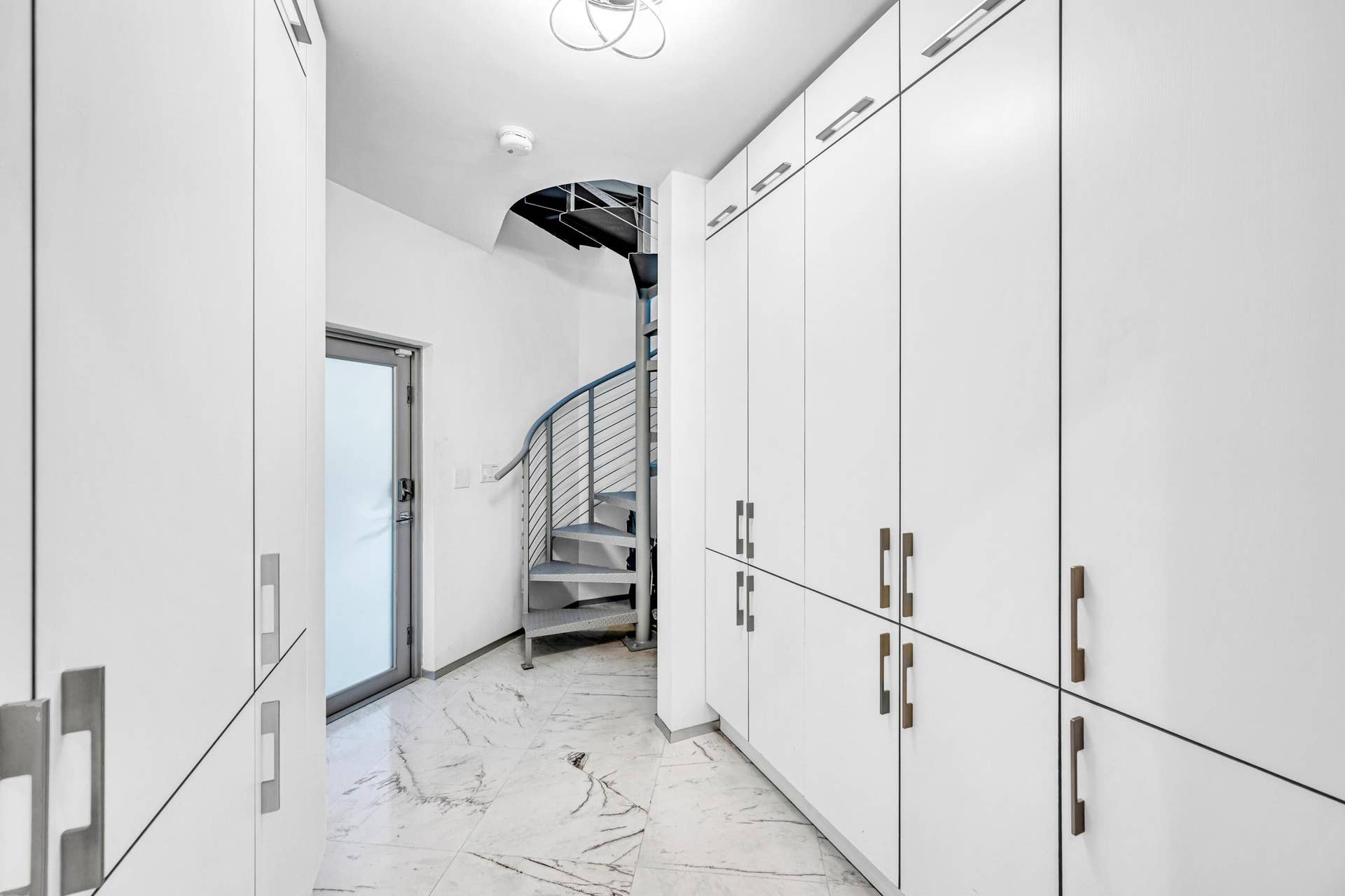 510 SW 18th Avenue, Fort Lauderdale, FL 33312 Custom built-in storage cabinetry, polished tile flooring, contemporary spiral staircase, and modern door with frosted glass