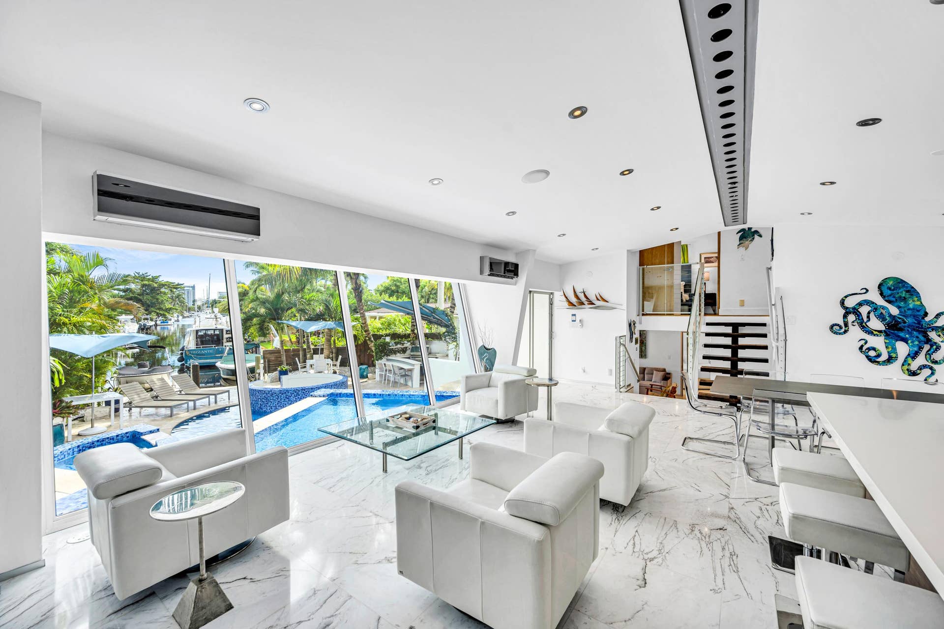 510 SW 18th Avenue, Fort Lauderdale, FL 33312 Expansive floor-to-ceiling windows, white marble-finish flooring, recessed lighting, built-in bar, and a geometric staircase