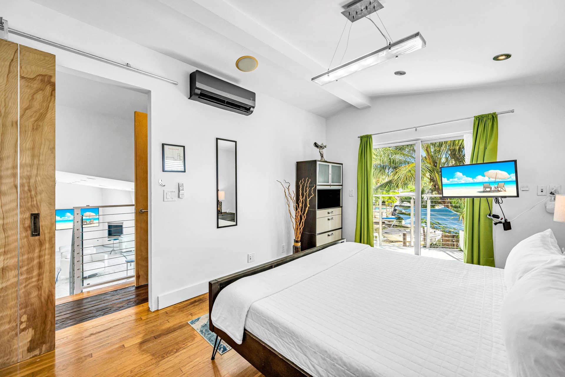 510 SW 18th Avenue, Fort Lauderdale, FL 33312 Hardwood flooring, sliding barn door, wall-mounted air conditioning unit, recessed lighting, and glass sliding doors with exterior access