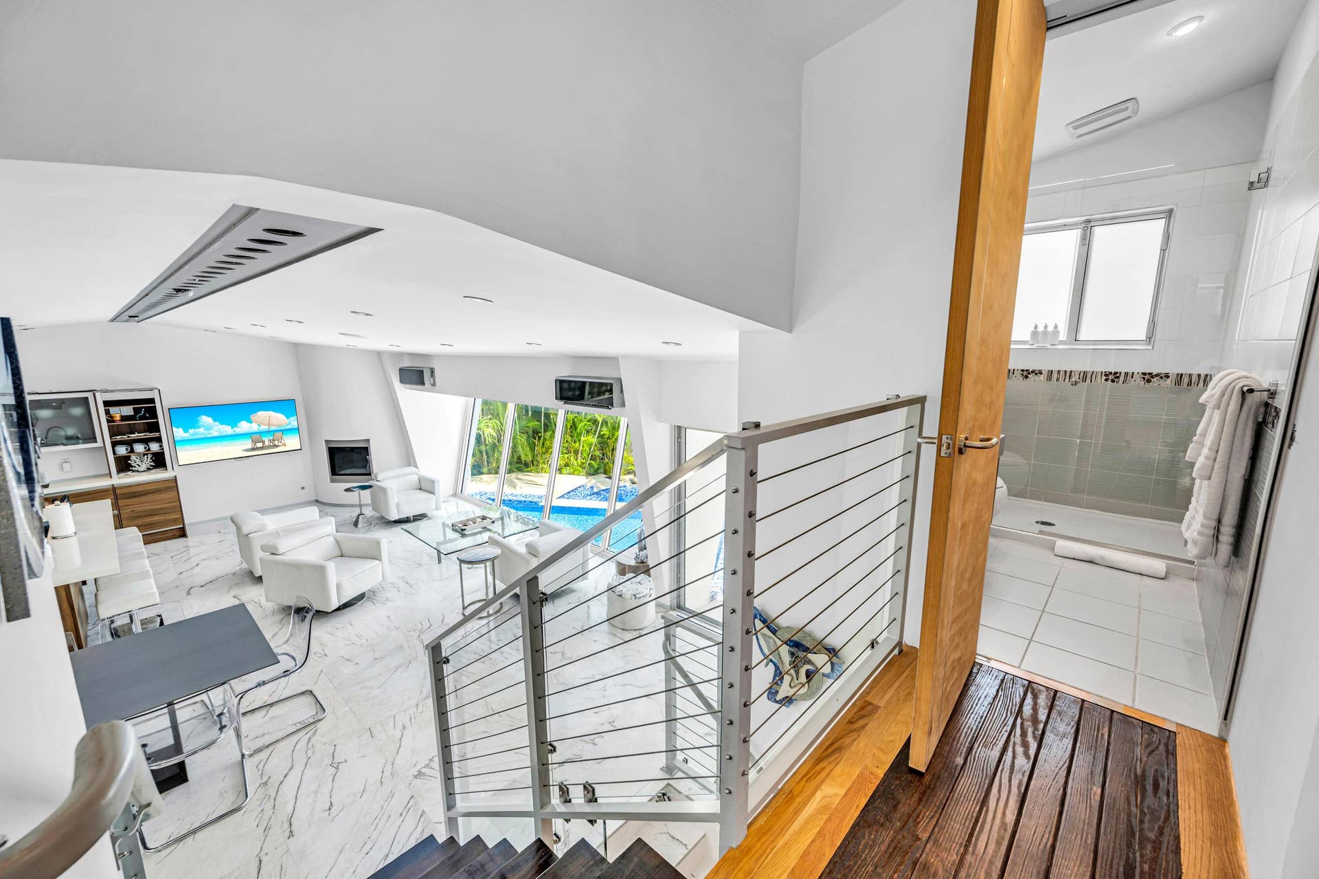 510 SW 18th Avenue, Fort Lauderdale, FL 33312 White marble-look flooring, glass and cable railing, built-in fireplace, full-height windows, and a built-in shower with tiled walls