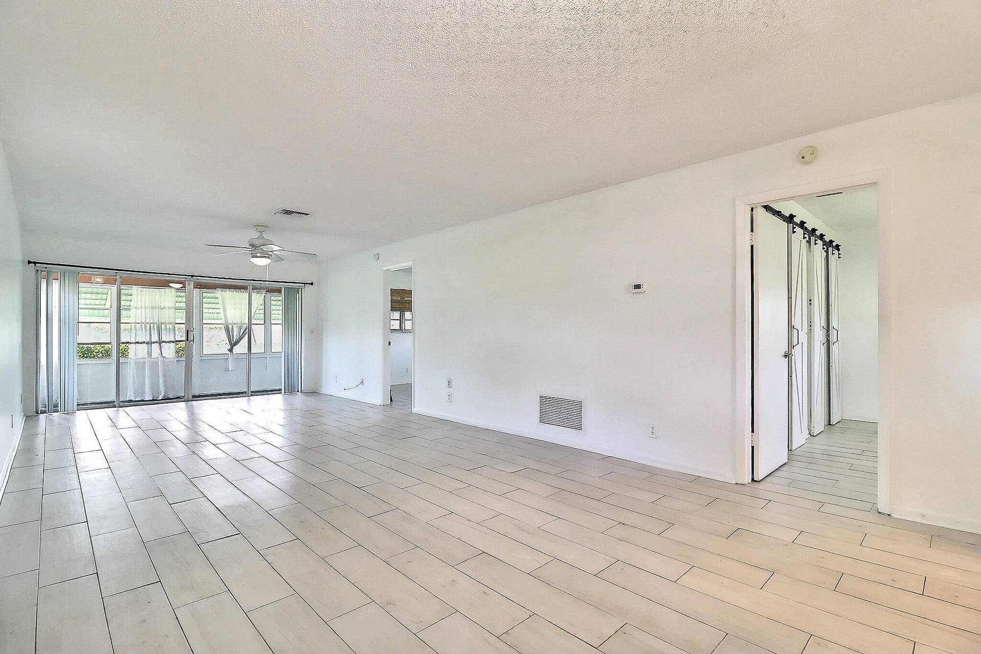 450 BLUEBIRD Lane, Delray Beach, FL 33445 Spacious living area featuring light-toned tile flooring, white walls, and a ceiling fan