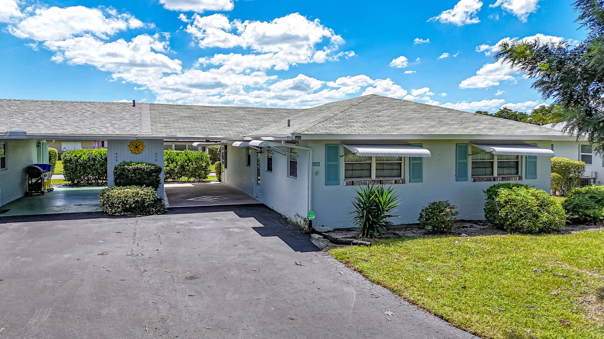 450 BLUEBIRD Lane, Delray Beach, FL 33445 Single-story residence featuring a gray shingle roof, light-colored exterior, and light blue window shutters