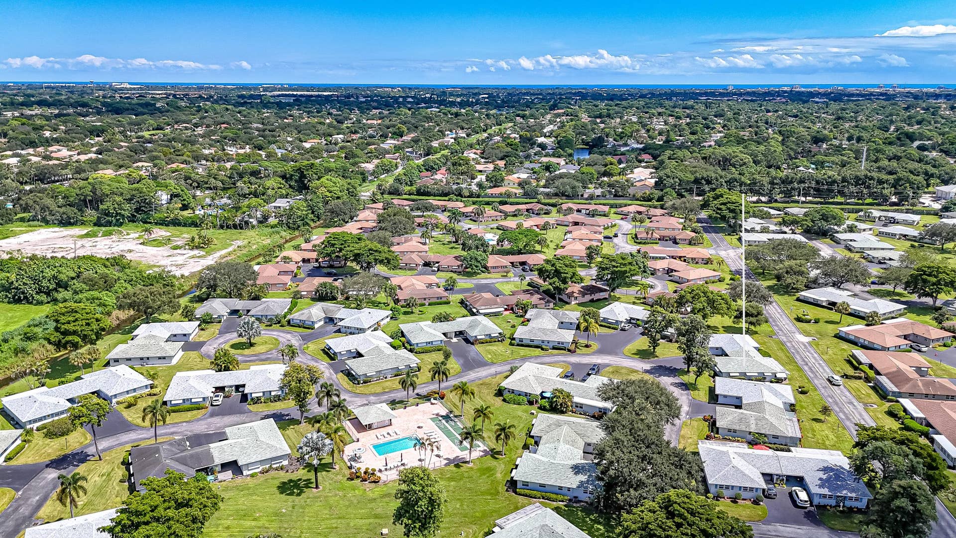 450 BLUEBIRD Lane, Delray Beach, FL 33445 Aerial perspective showcasing a residential community with mature landscaping