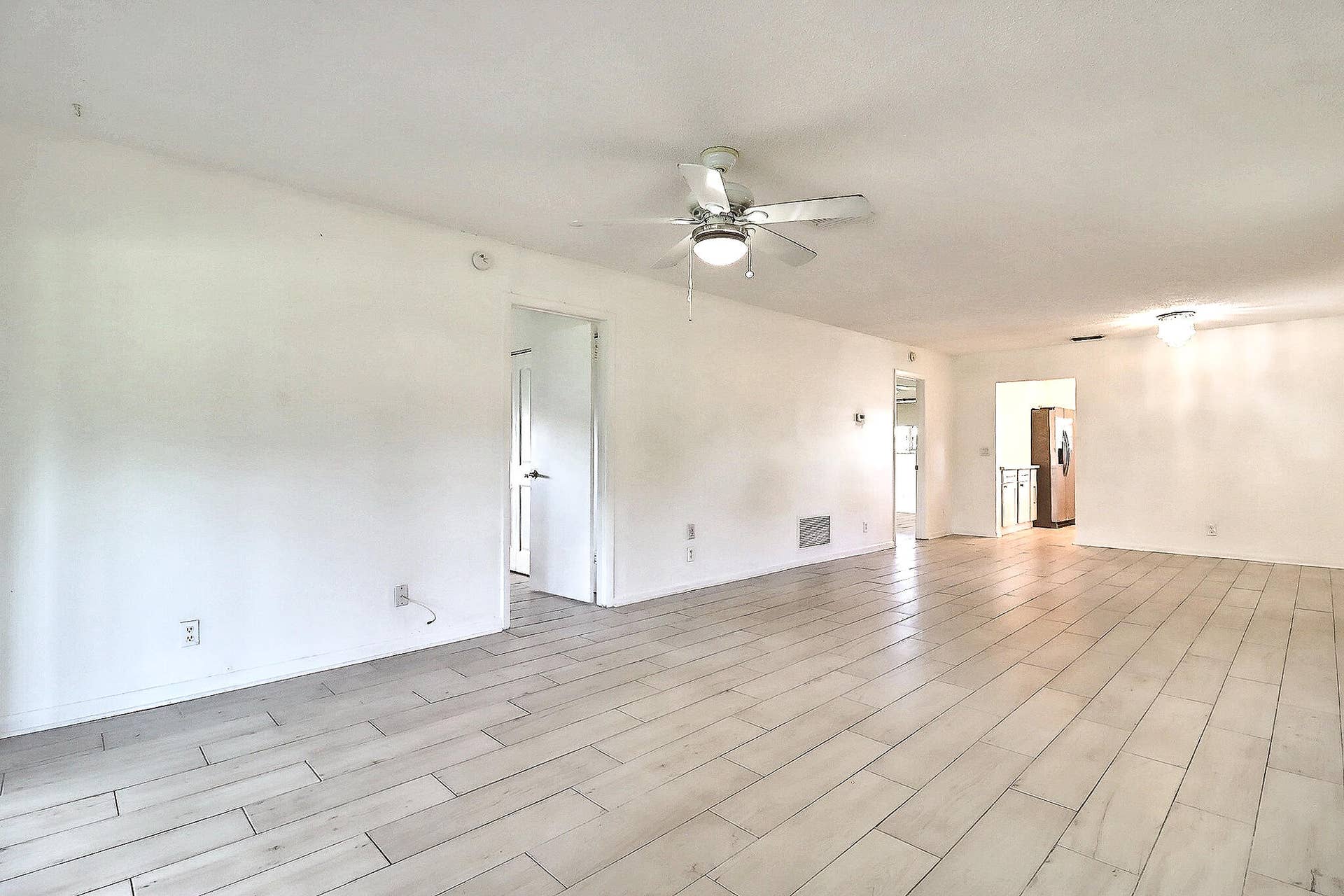 450 BLUEBIRD Lane, Delray Beach, FL 33445 Spacious interior featuring wood-finish tile flooring, recessed lighting, and a ceiling fan with integrated lighting