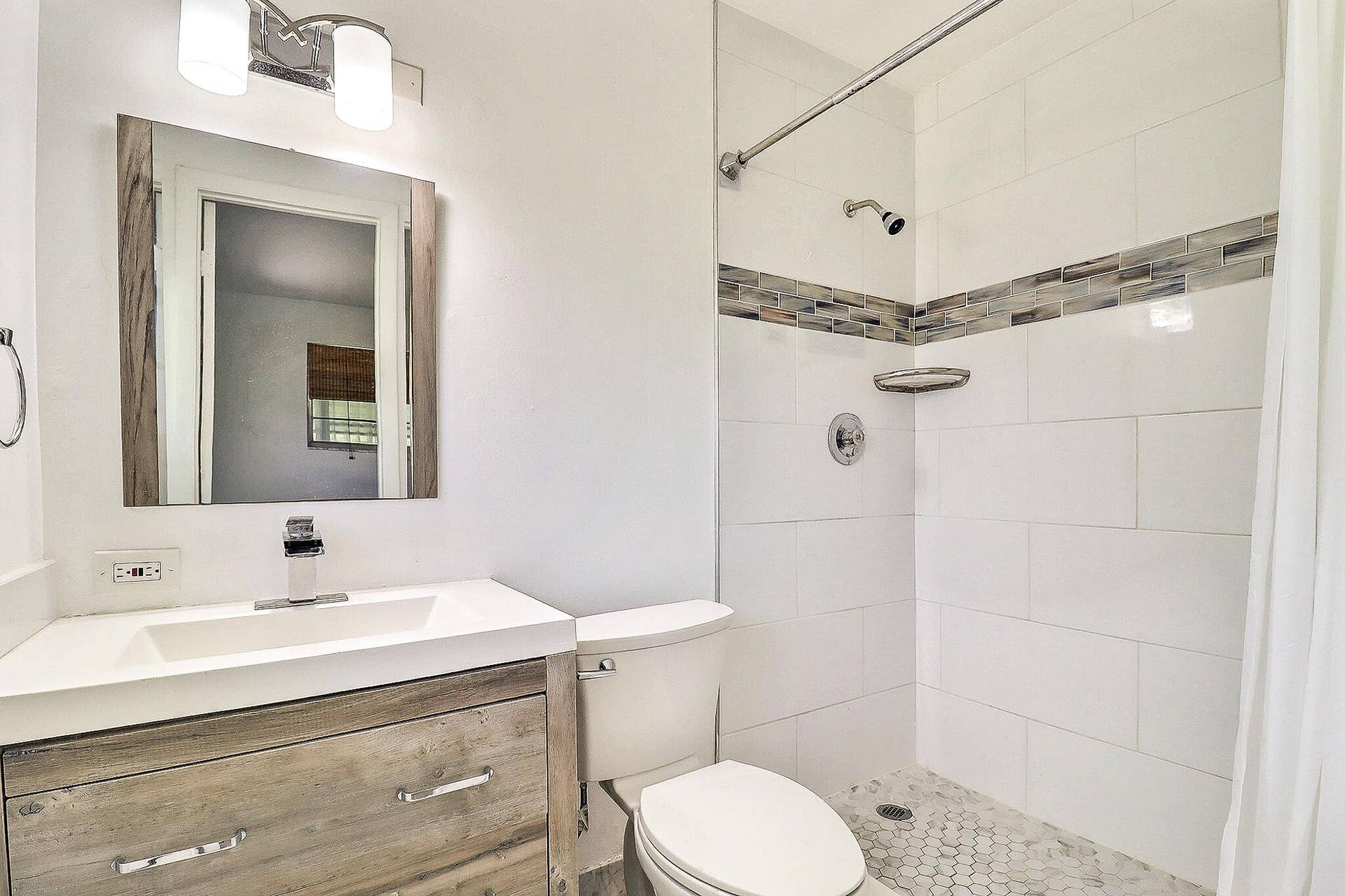 450 BLUEBIRD Lane, Delray Beach, FL 33445 Vanity with wood-finish cabinetry, integrated sink, and chrome faucet