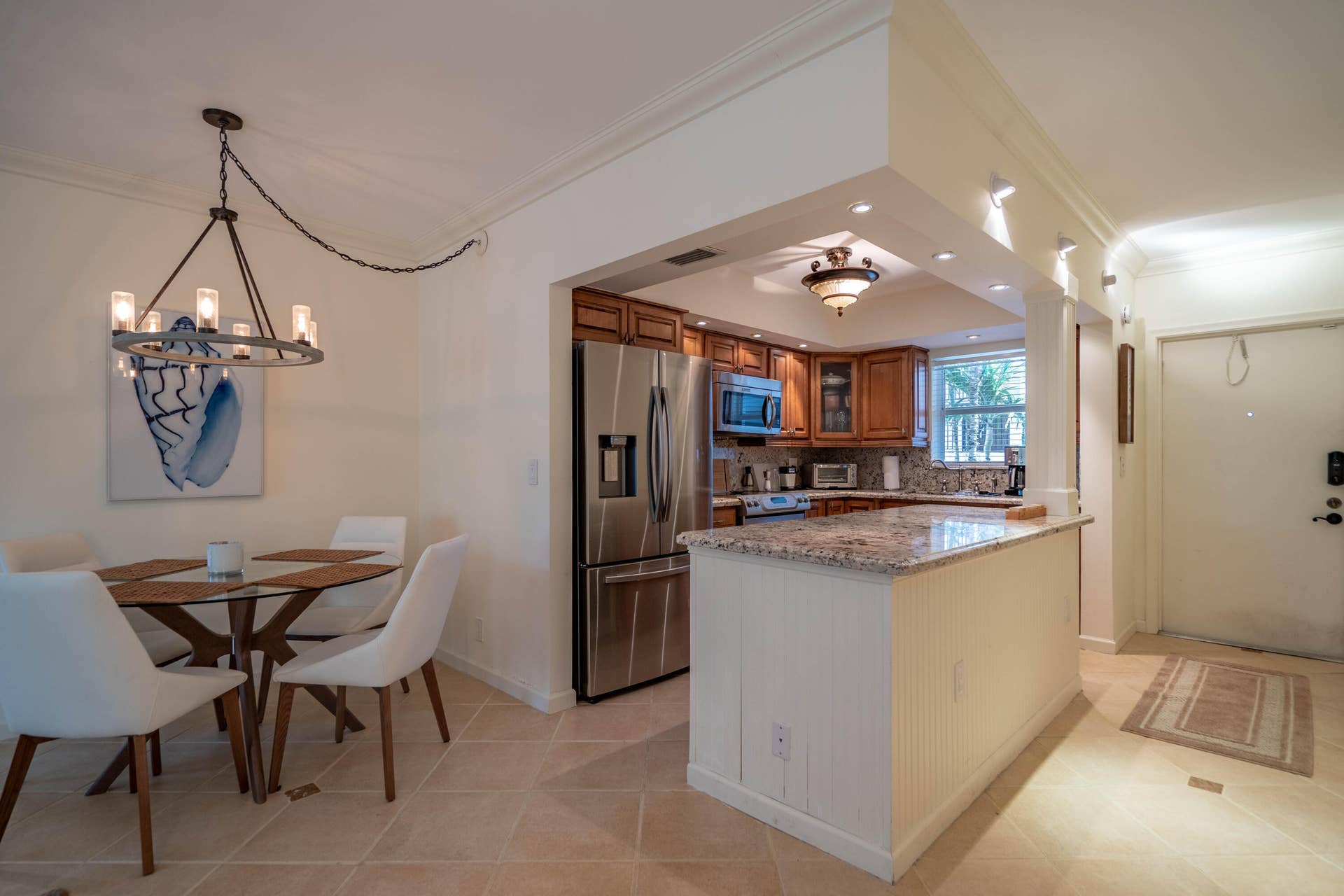 Kitchen featuring stainless steel appliances, wood cabinetry, and a granite-finish countertop island