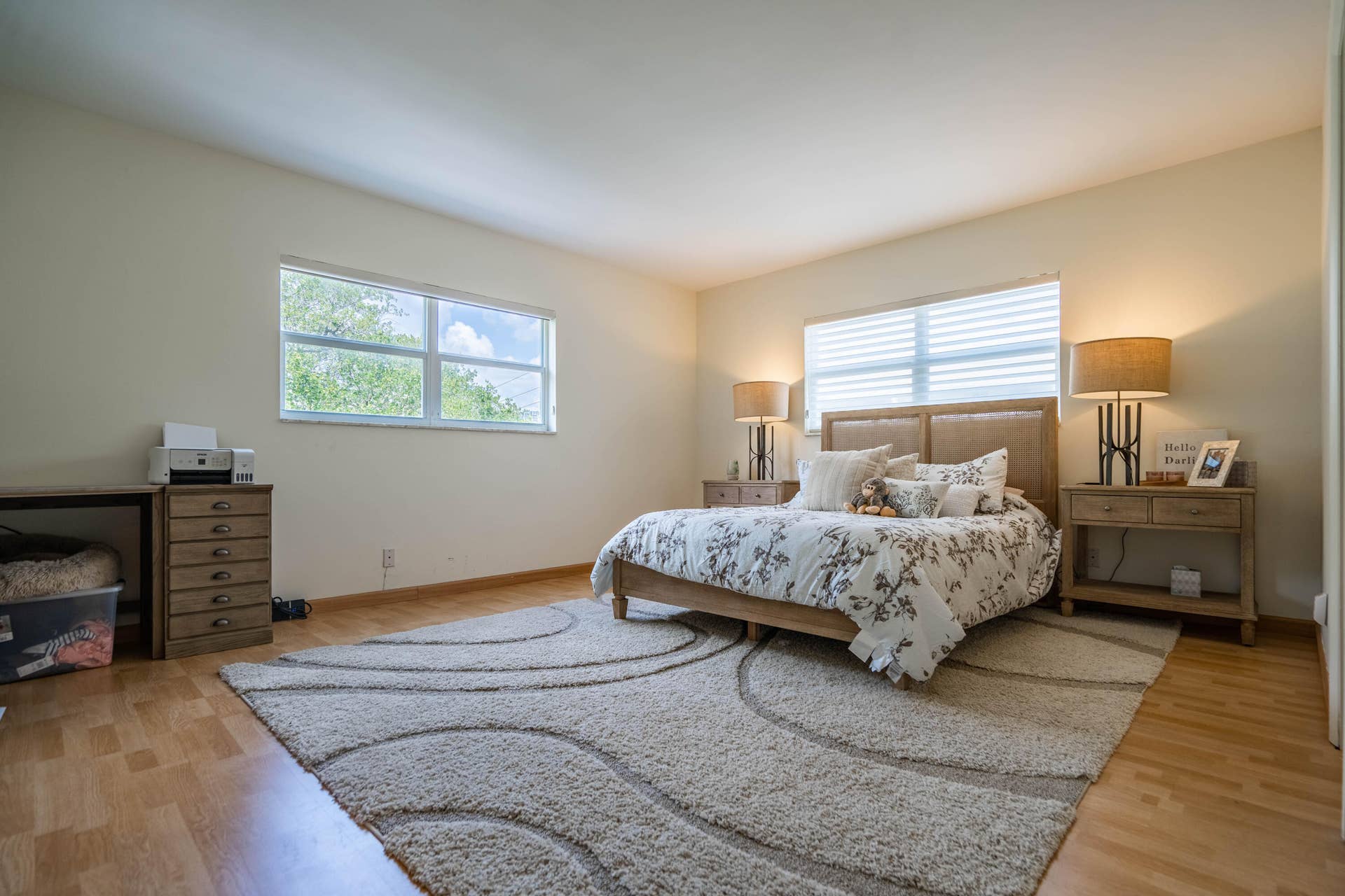 Light-toned walls, wood-finish flooring, and multiple windows with horizontal blinds