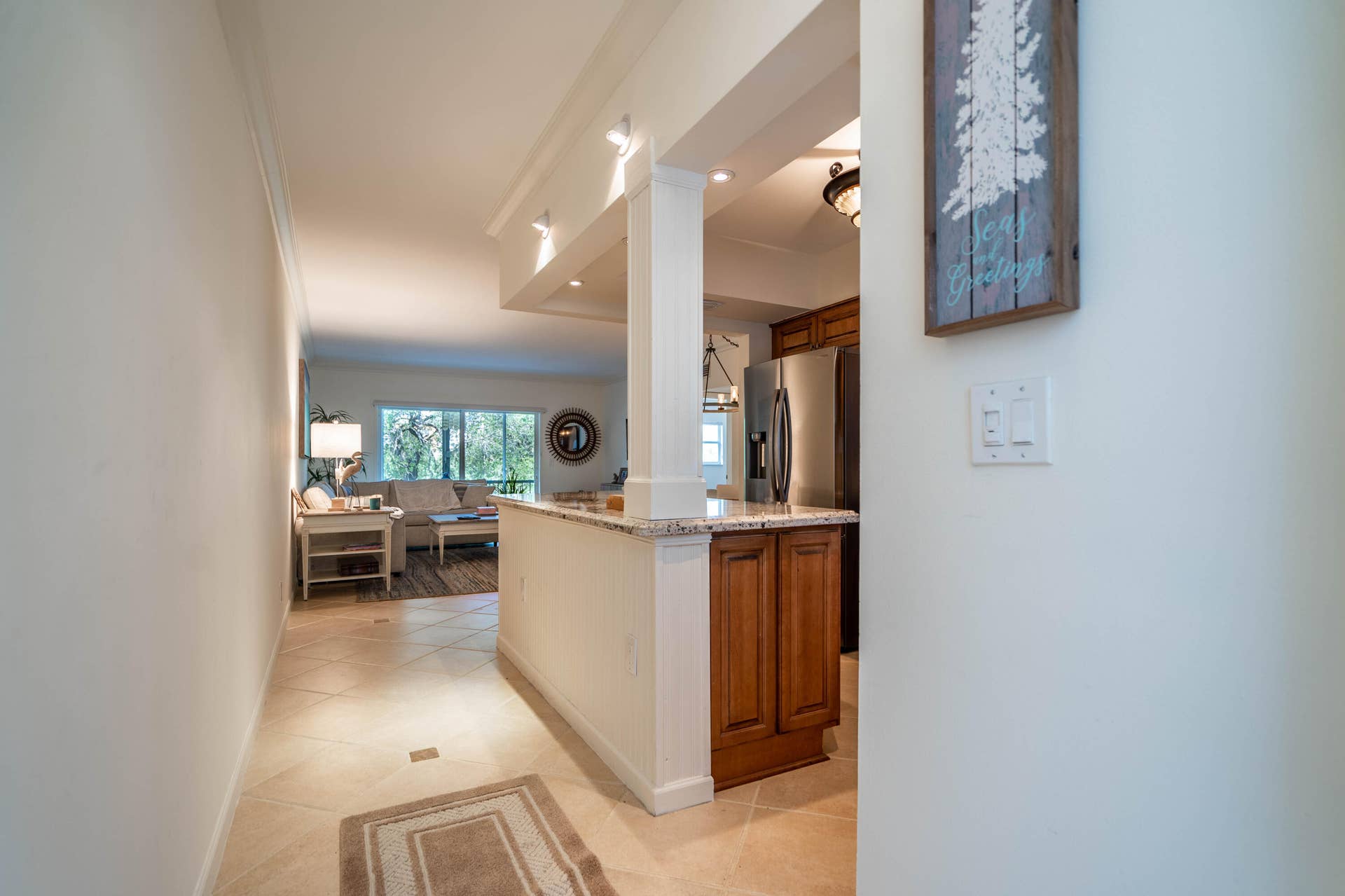 Tile flooring, recessed lighting, granite countertop, wood-finish cabinetry, and stainless steel appliance