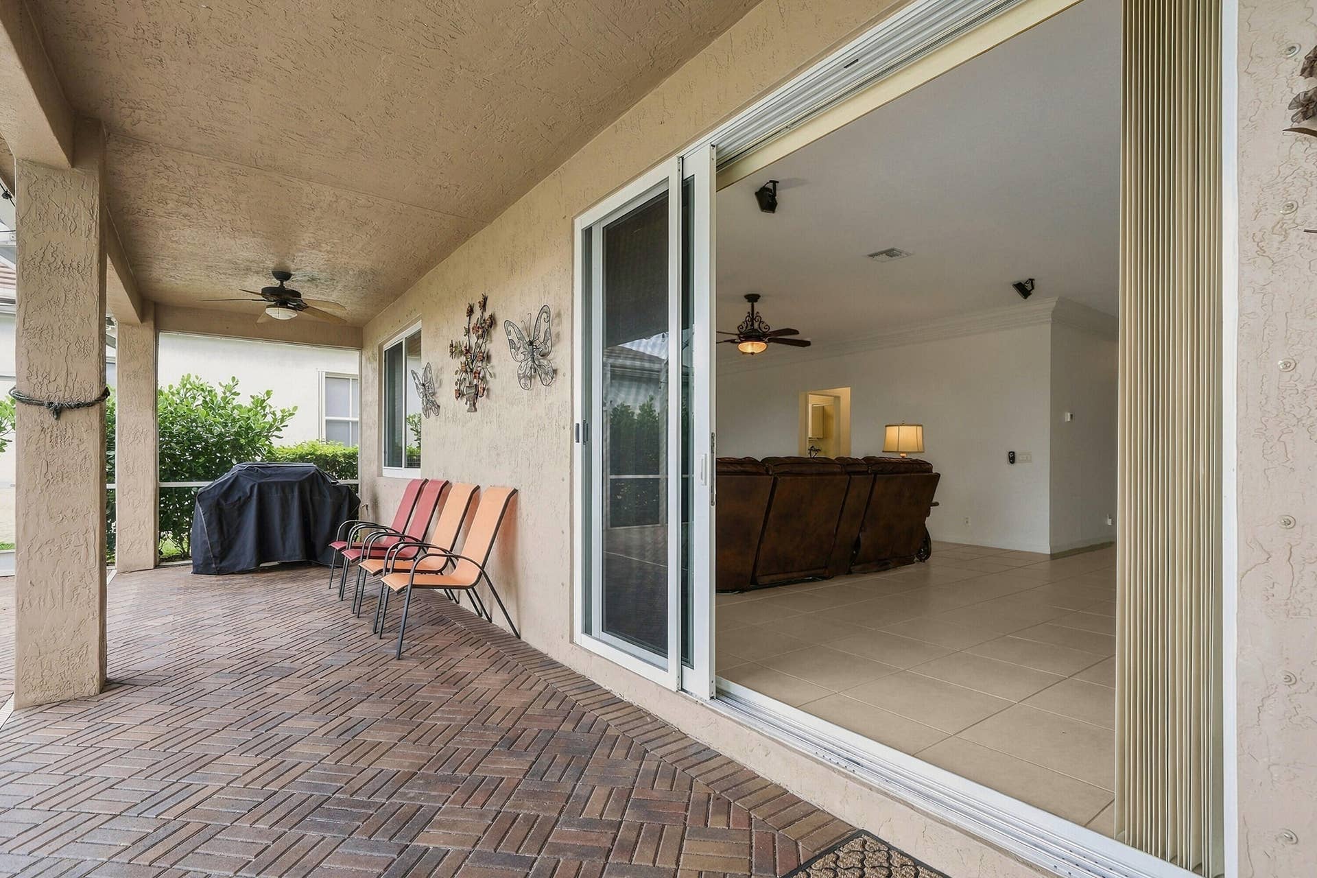 1020 Lavender Circle, Weston, FL 33327 Covered patio featuring a brick paver floor, ceiling fan, and sliding glass doors