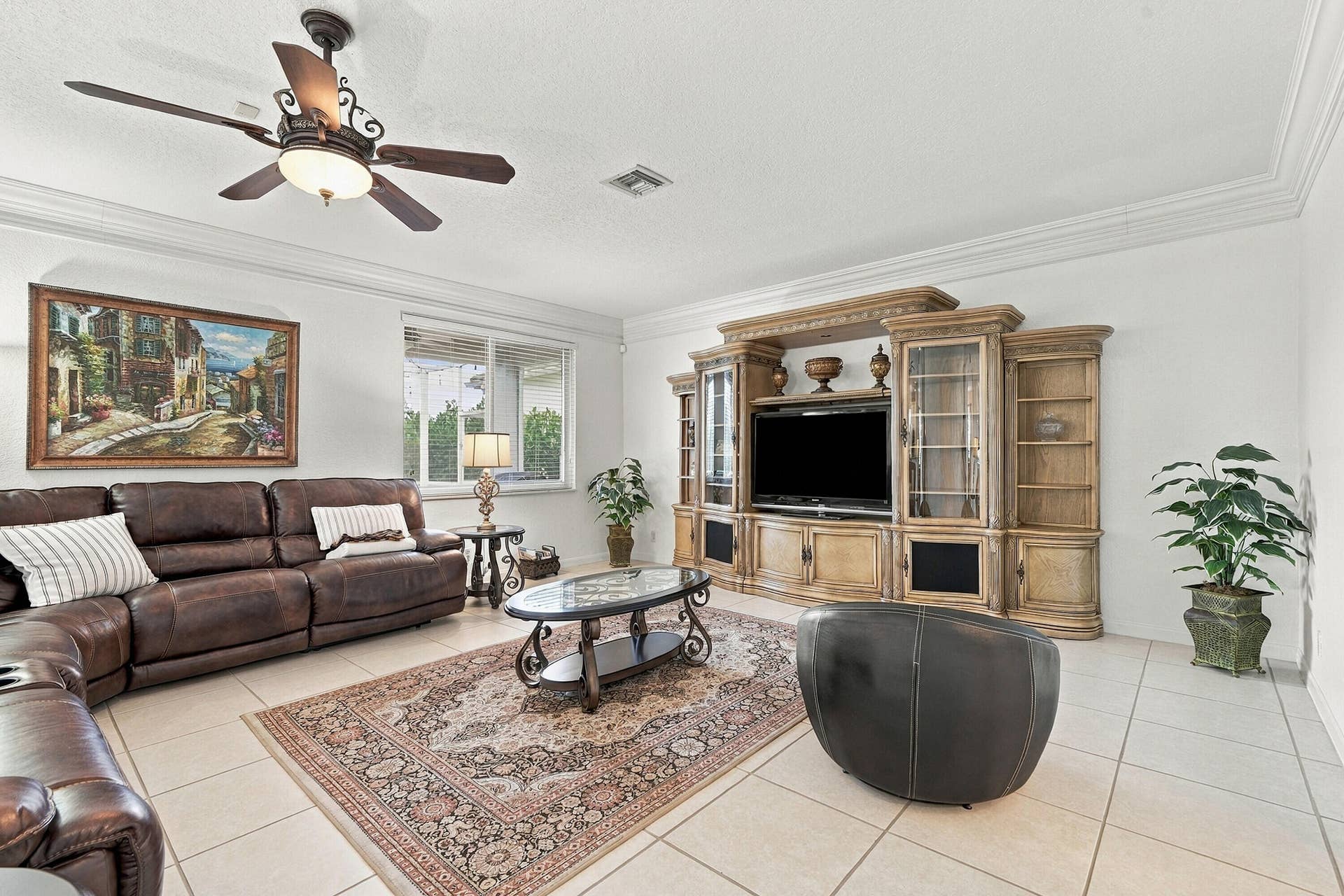 1020 Lavender Circle, Weston, FL 33327 White tile flooring, crown molding, a ceiling fan with integrated lighting, a built-in entertainment center, and a window with exterior views