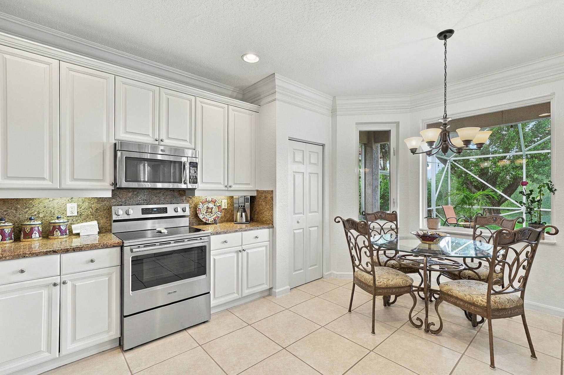 1020 Lavender Circle, Weston, FL 33327 White cabinetry, stainless steel appliances, bay window, tile flooring, and recessed lighting