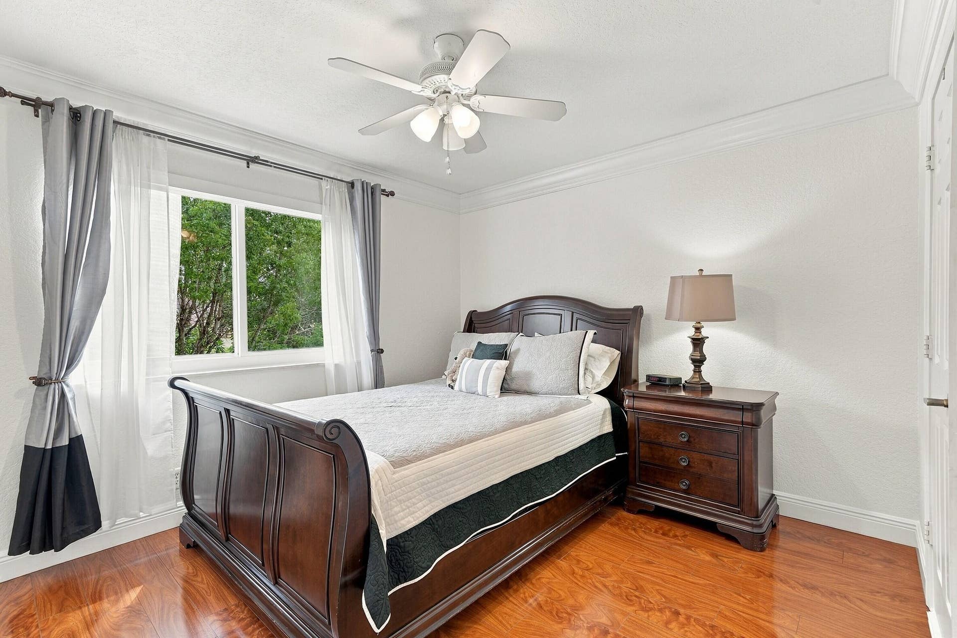 1020 Lavender Circle, Weston, FL 33327 White walls featuring crown molding, a ceiling fan with integrated lighting, wood-finish flooring, and a large window