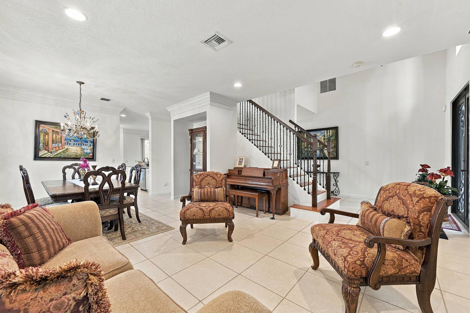 1020 Lavender Circle, Weston, FL 33327 Tile flooring, recessed lighting, crown molding, a decorative chandelier, and a staircase with wrought iron balusters