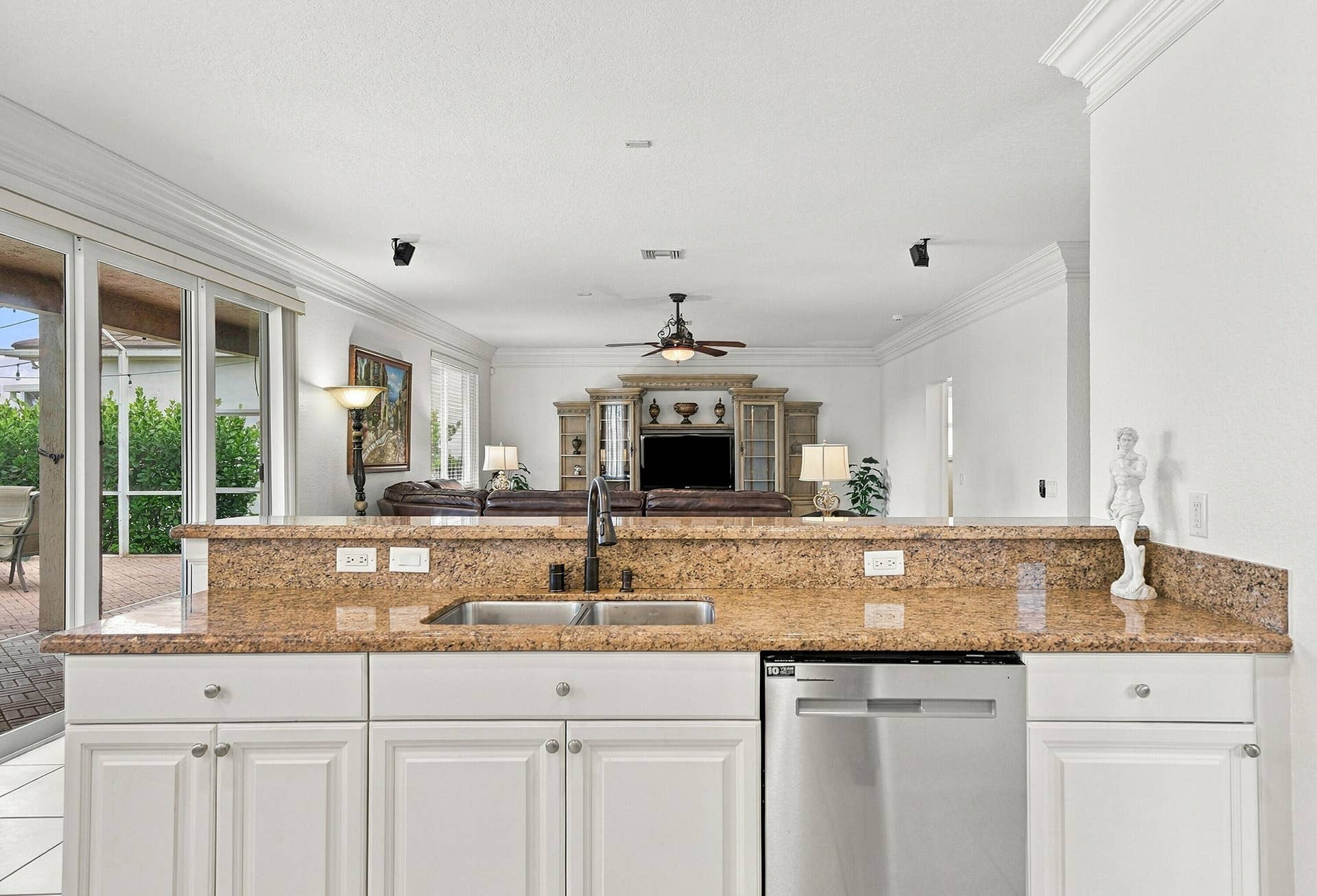 1020 Lavender Circle, Weston, FL 33327 Kitchen featuring white cabinetry, a stainless steel dishwasher, an undermount double-basin sink with a matte black faucet, and stone countertops